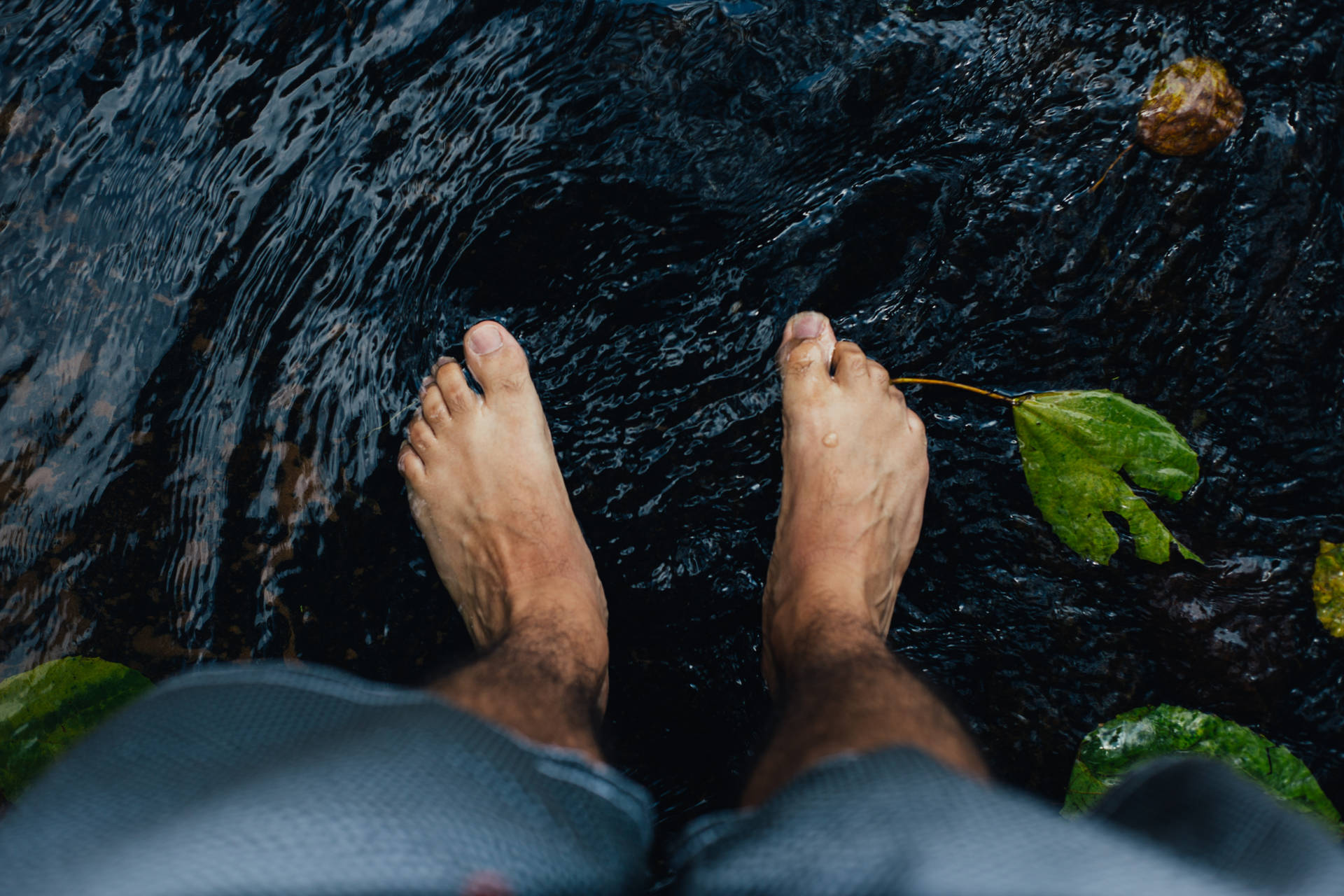 Feet Submerged In A Dark Water Background