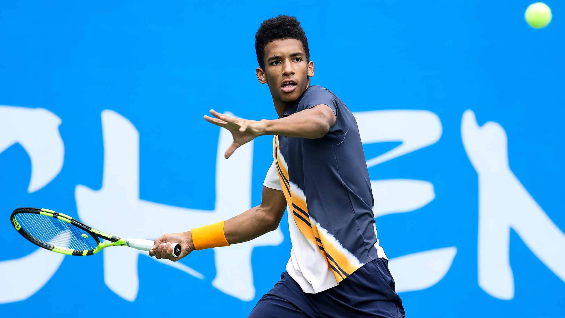 Felix Auger-aliassime Concentrating On The Ball In Tennis Match Background