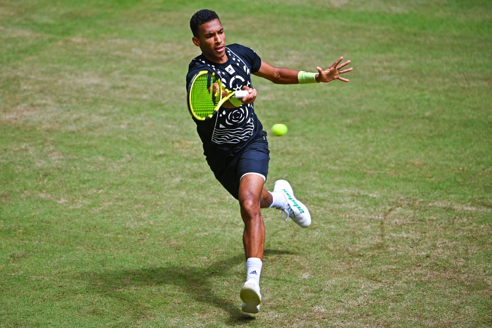 Felix Auger Aliassime In Action On A Grass Court Background