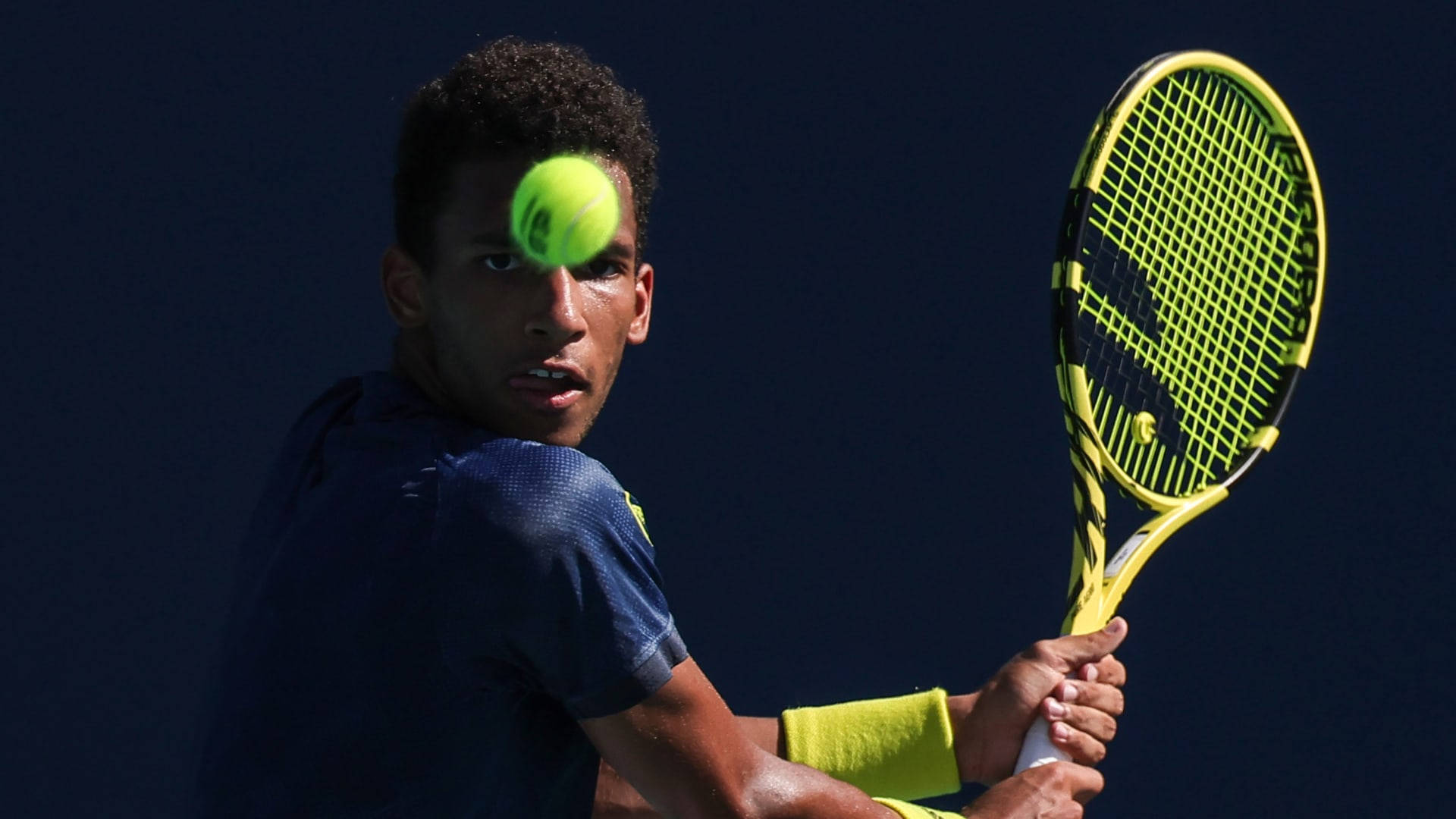 Felix Auger-aliassime Showcasing A Steady, Focused Expression During A Game. Background