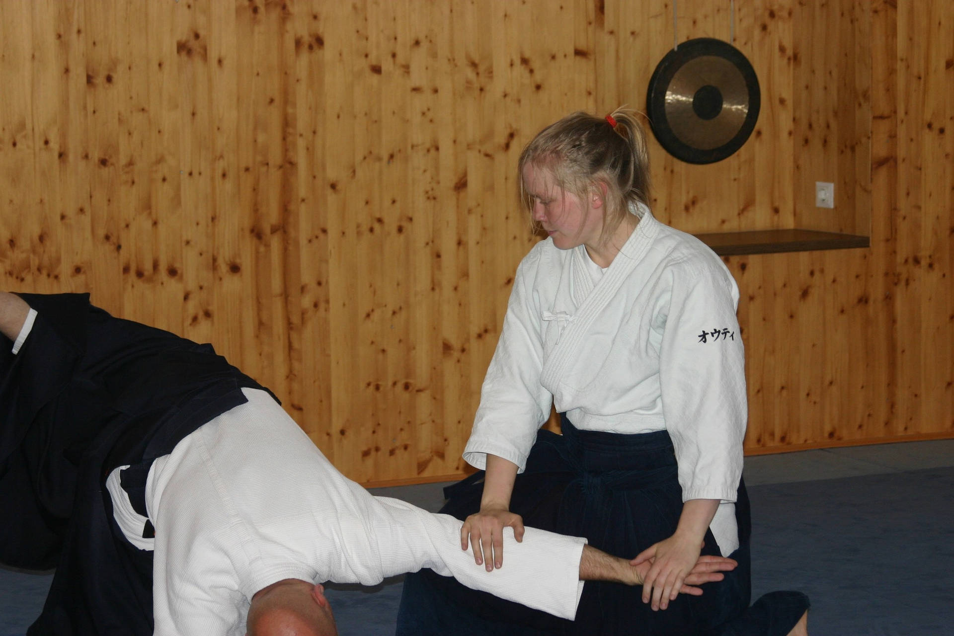 Female Aikidoka Executing Koshi Nage Technique Background