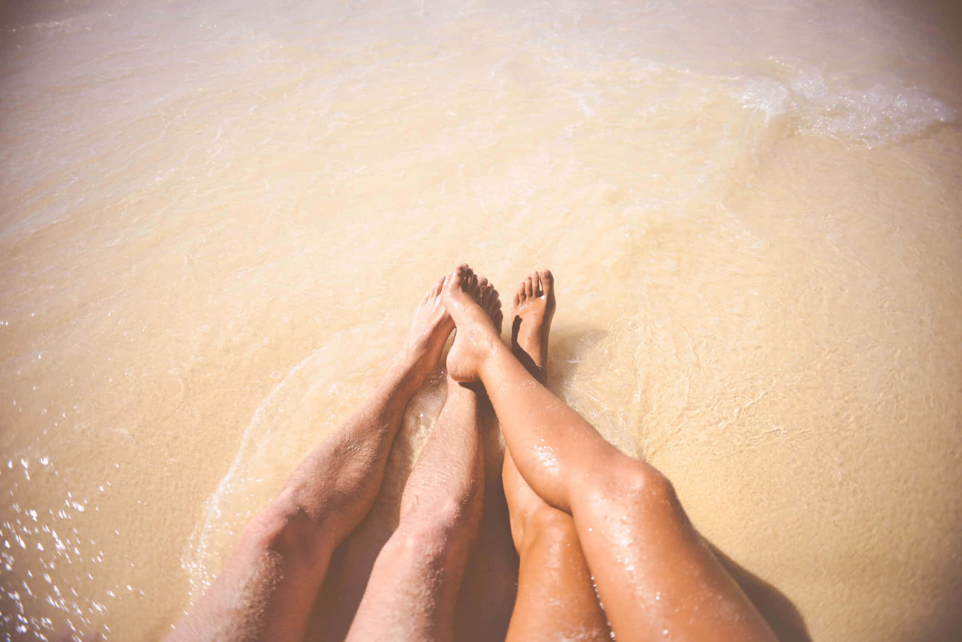 Female And Male Feet On The Seawater