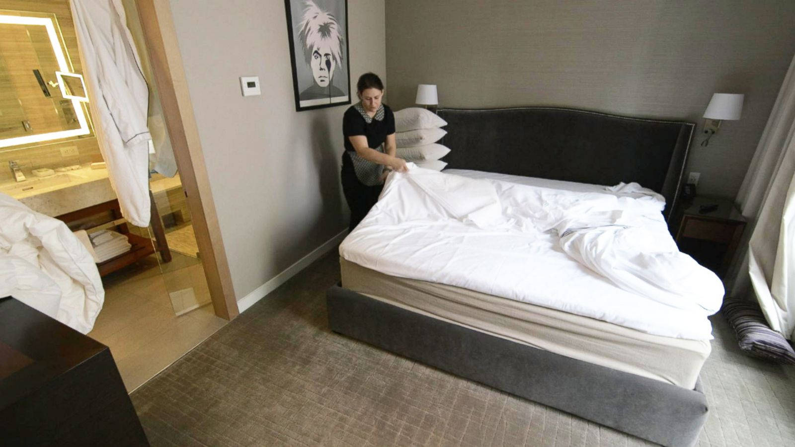 Female Hotel Housekeeper Changing Blanket Background