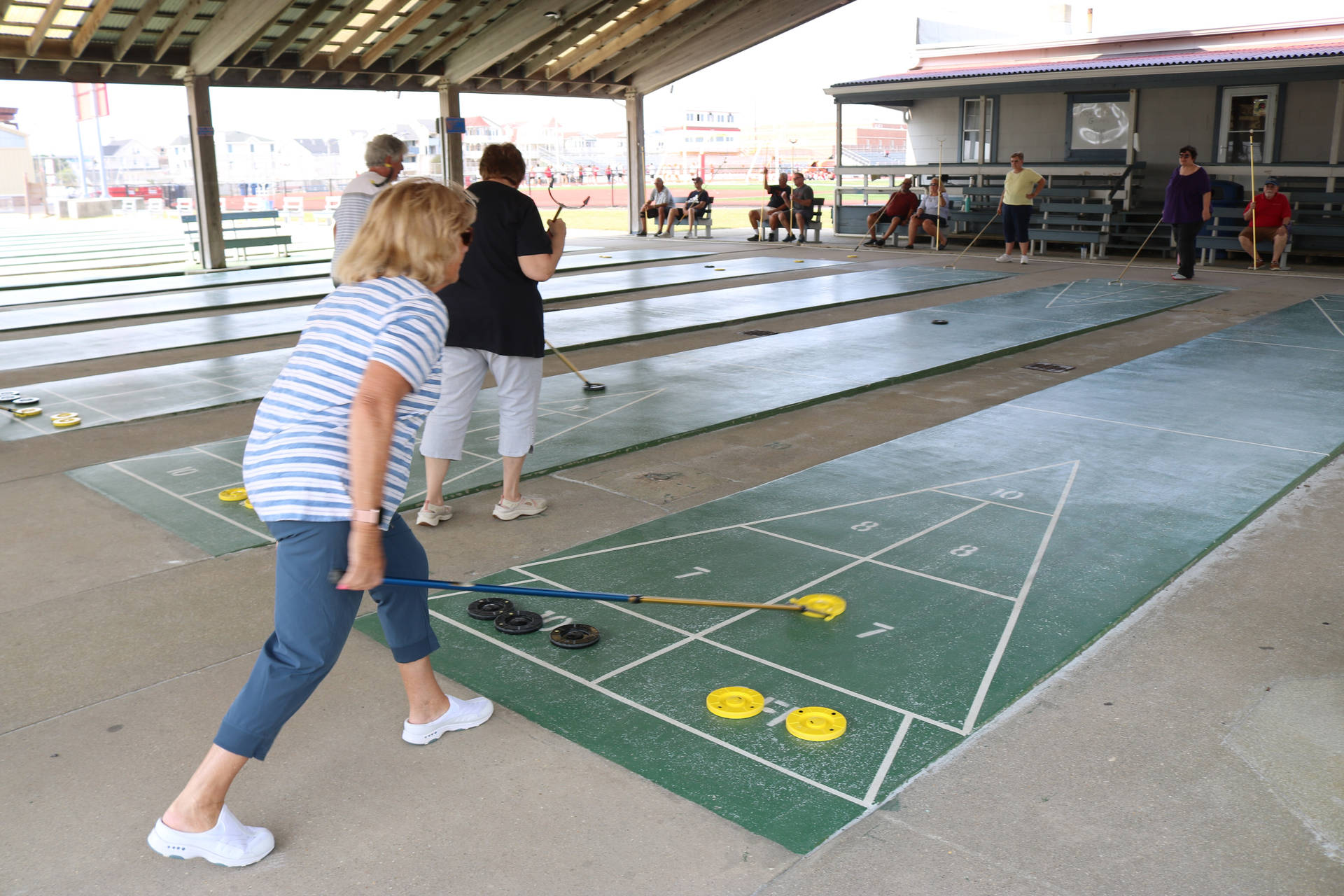 Female Playing Shuffleboard On Court Background