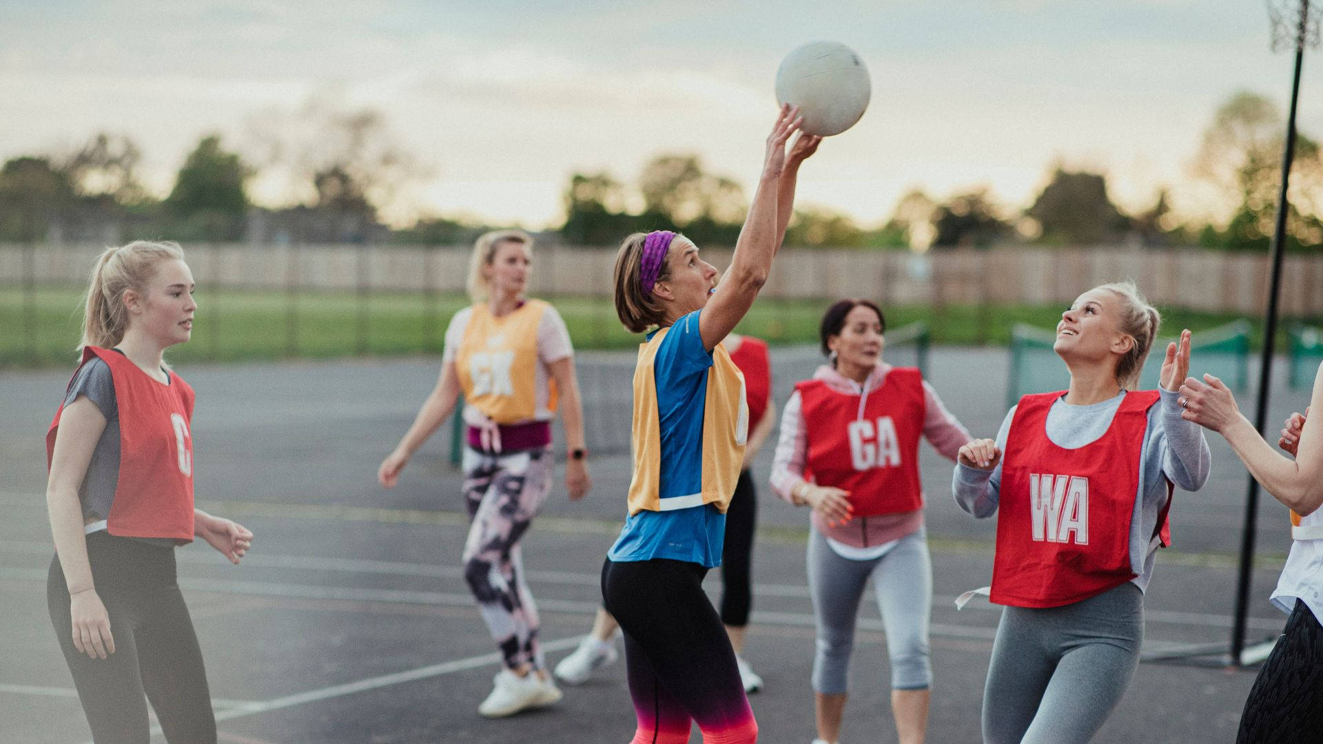 Female Students Playing Netball Shoot Goal