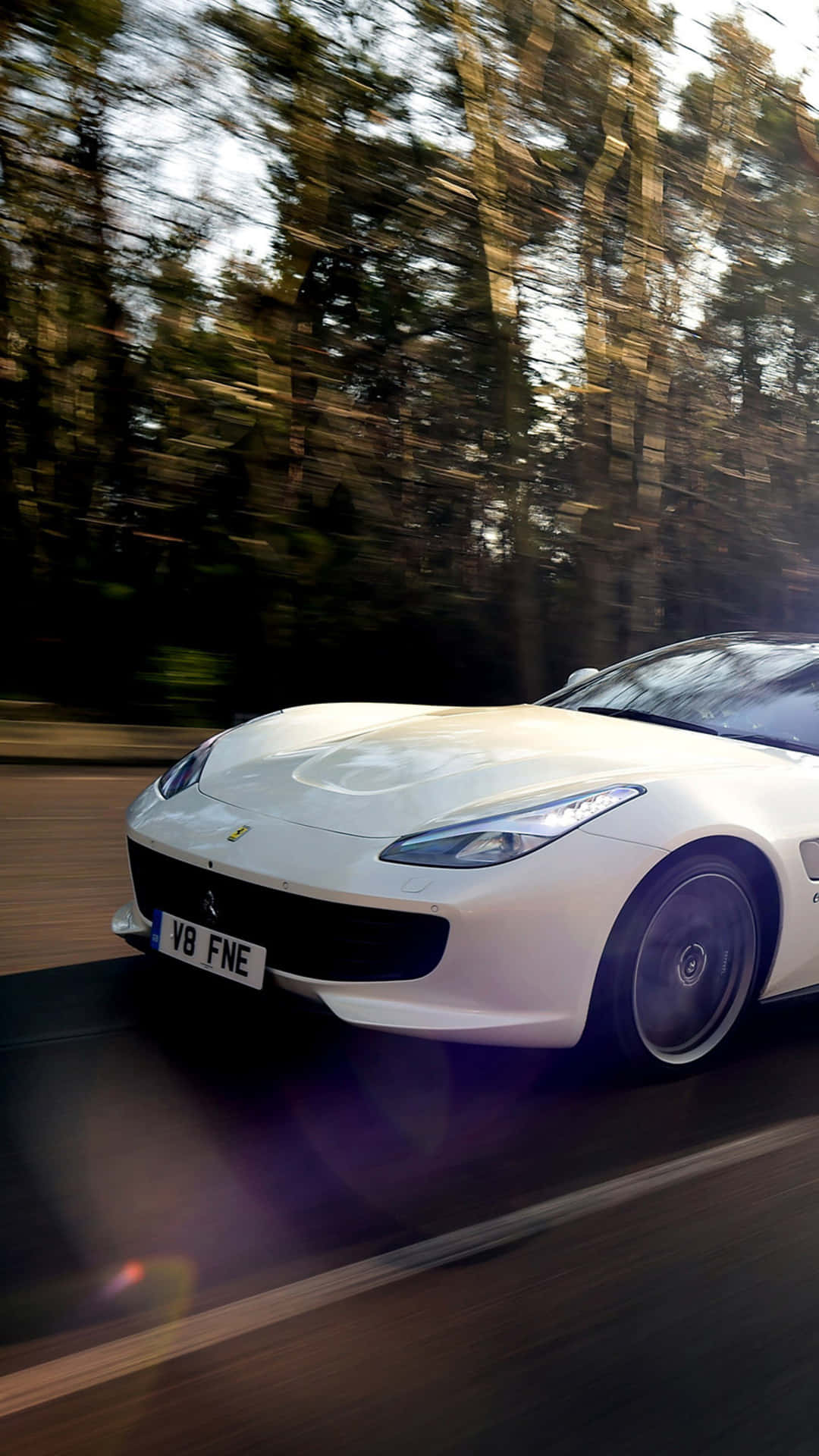 Ferrari F12tdb - A White Sports Car Driving Down A Road