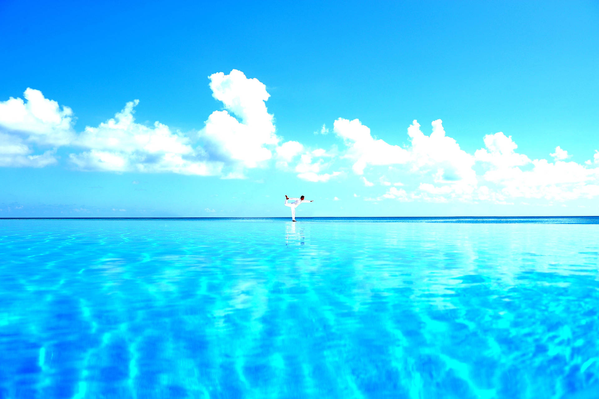 Finding Serenity: A Tranquil Yoga Pose Above Sparkling Blue Water Background