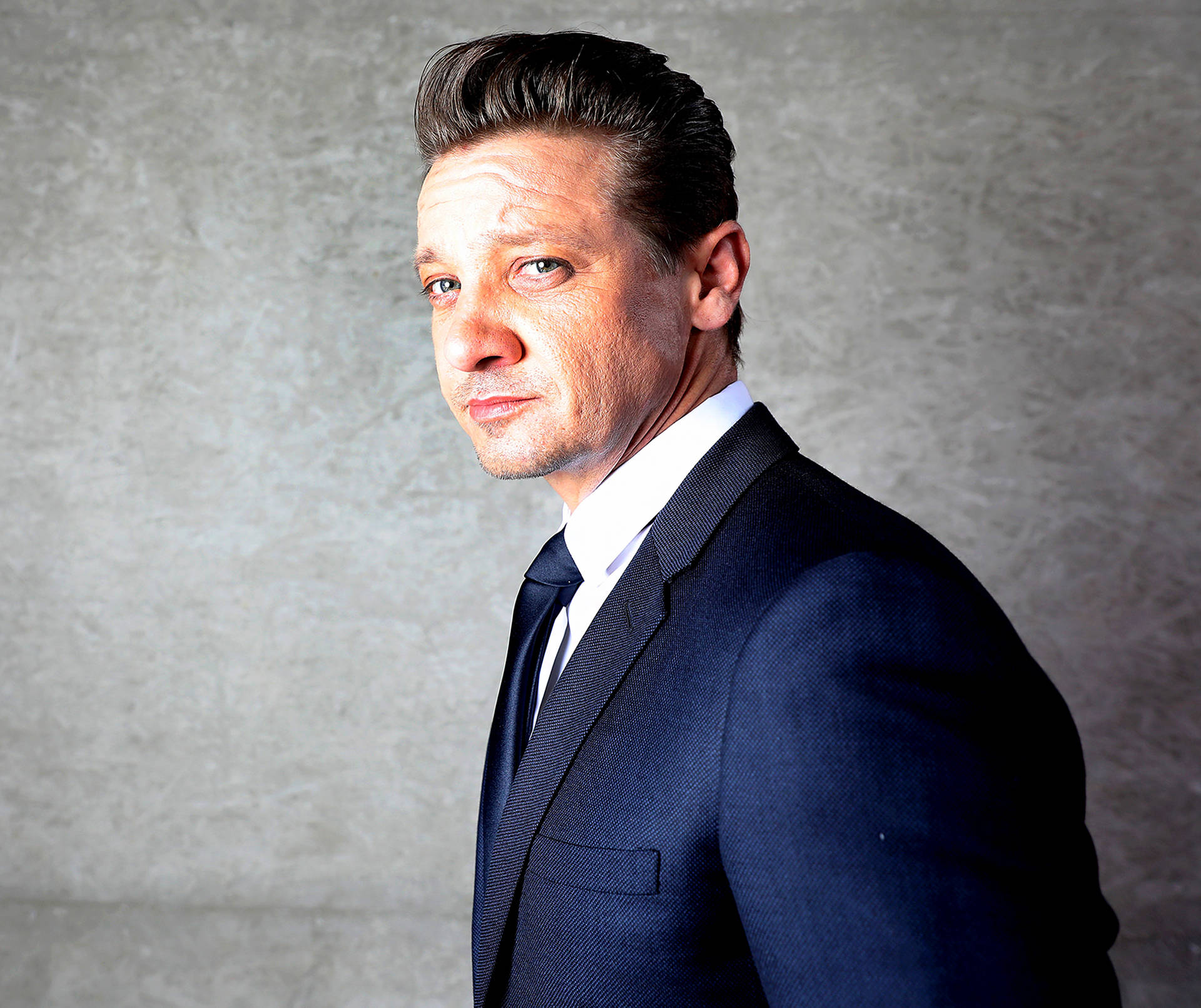 Fine Looking Jeremy Renner In Suit Background