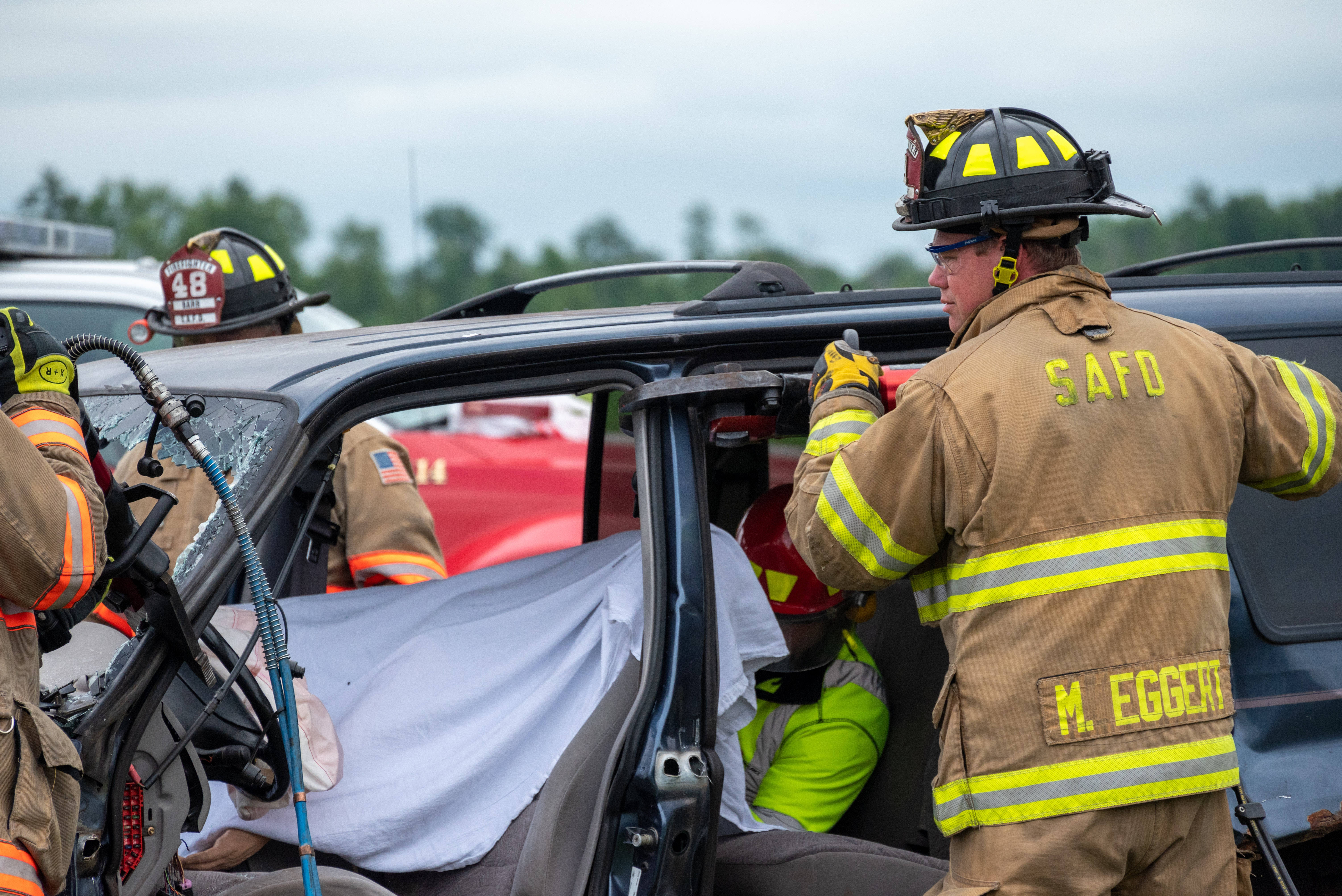 Firefighters At Car Accident Background