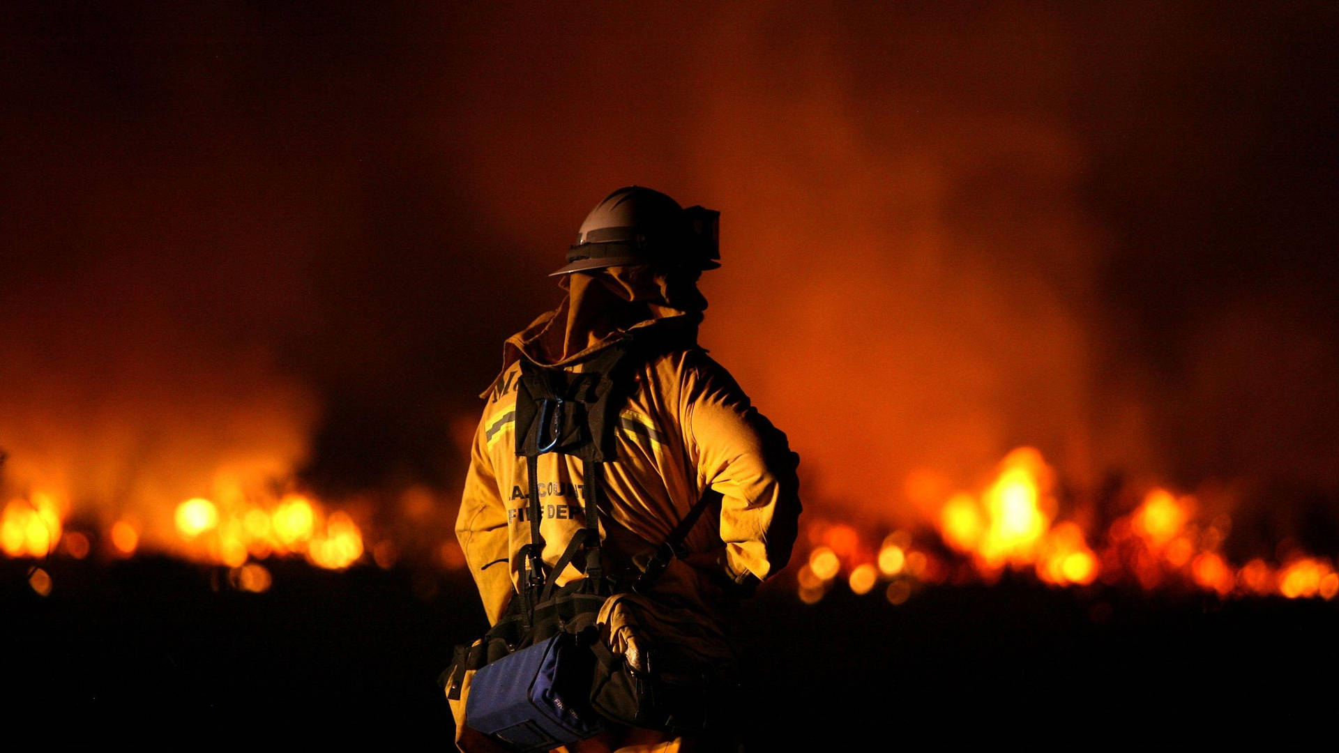 Firefighters In Front Of A Burning Space