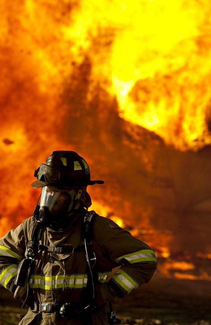 Firefighters In Front Of Fire Background