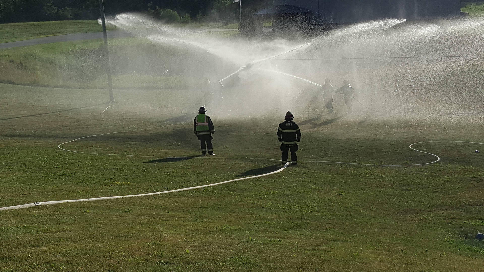 Firefighters Practicing Fire Hoses Background