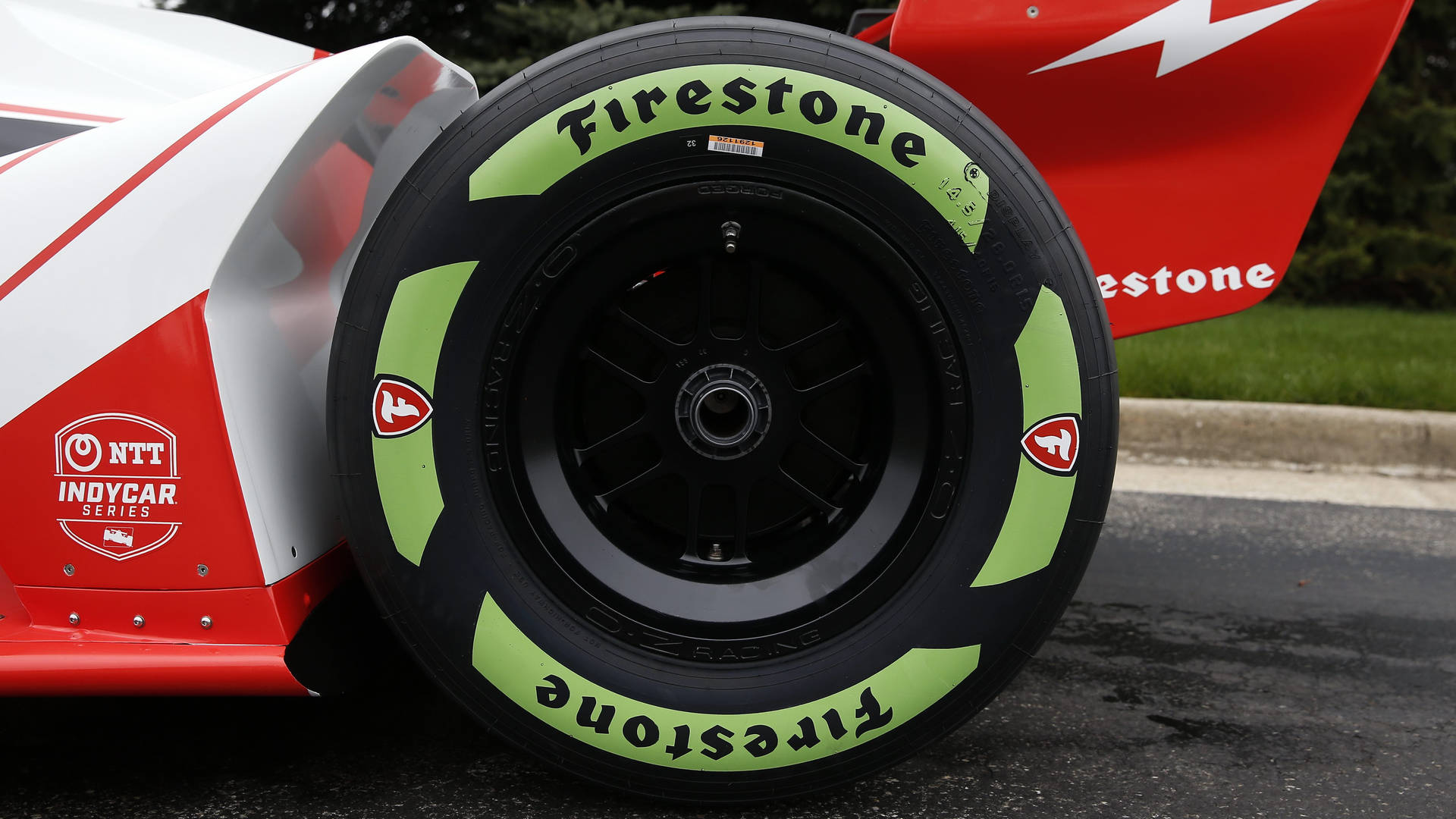 Firestone Black And Green Tire On Racecar Background