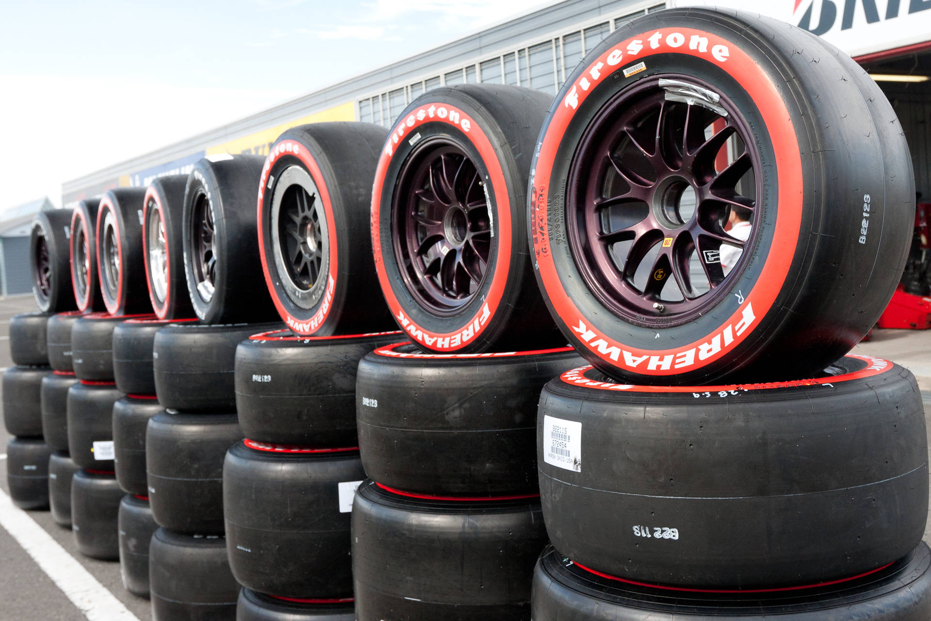 Firestone Black And Red Stacks Of Tires Background