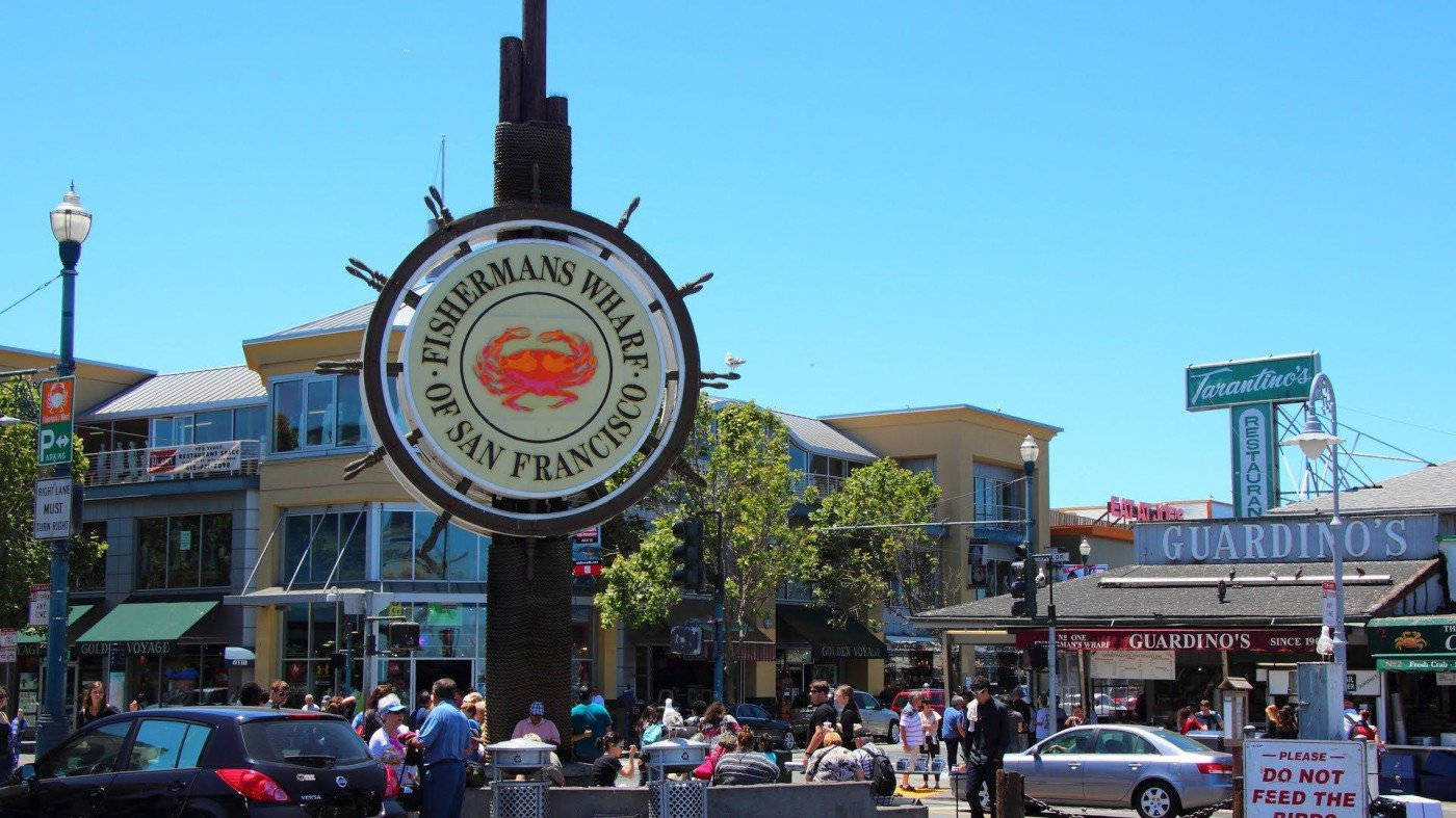 Fishermans Wharf Sign From A Distance Background