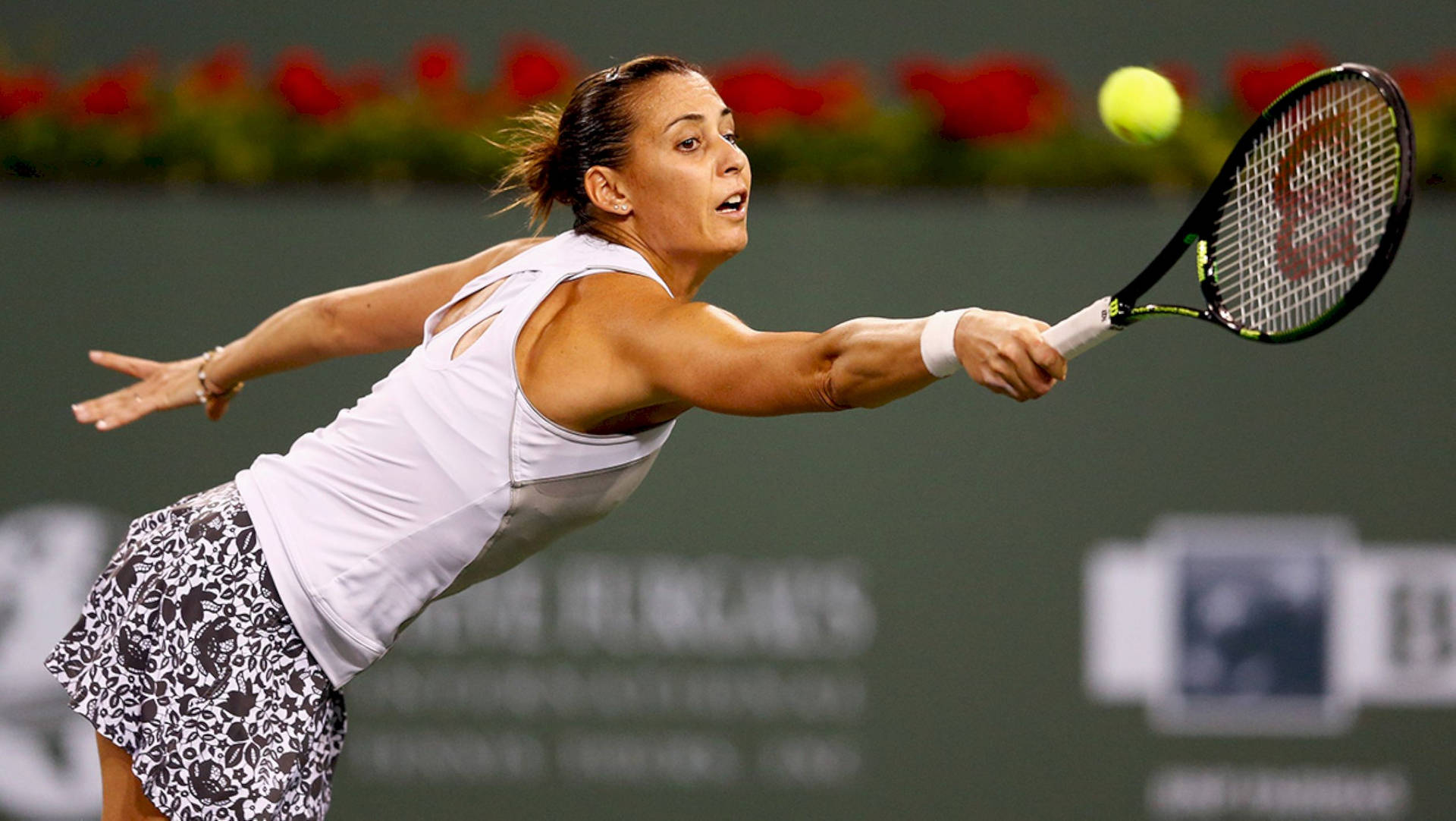 Flavia Pennetta Demonstrating Her Athletic Prowess On The Tennis Court Background