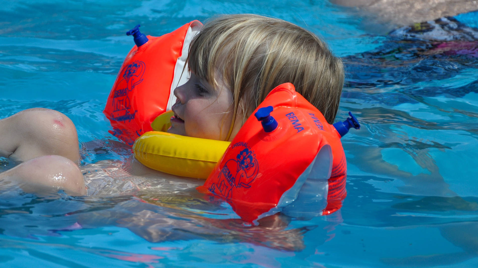 Floating Kid In Swimming Pool