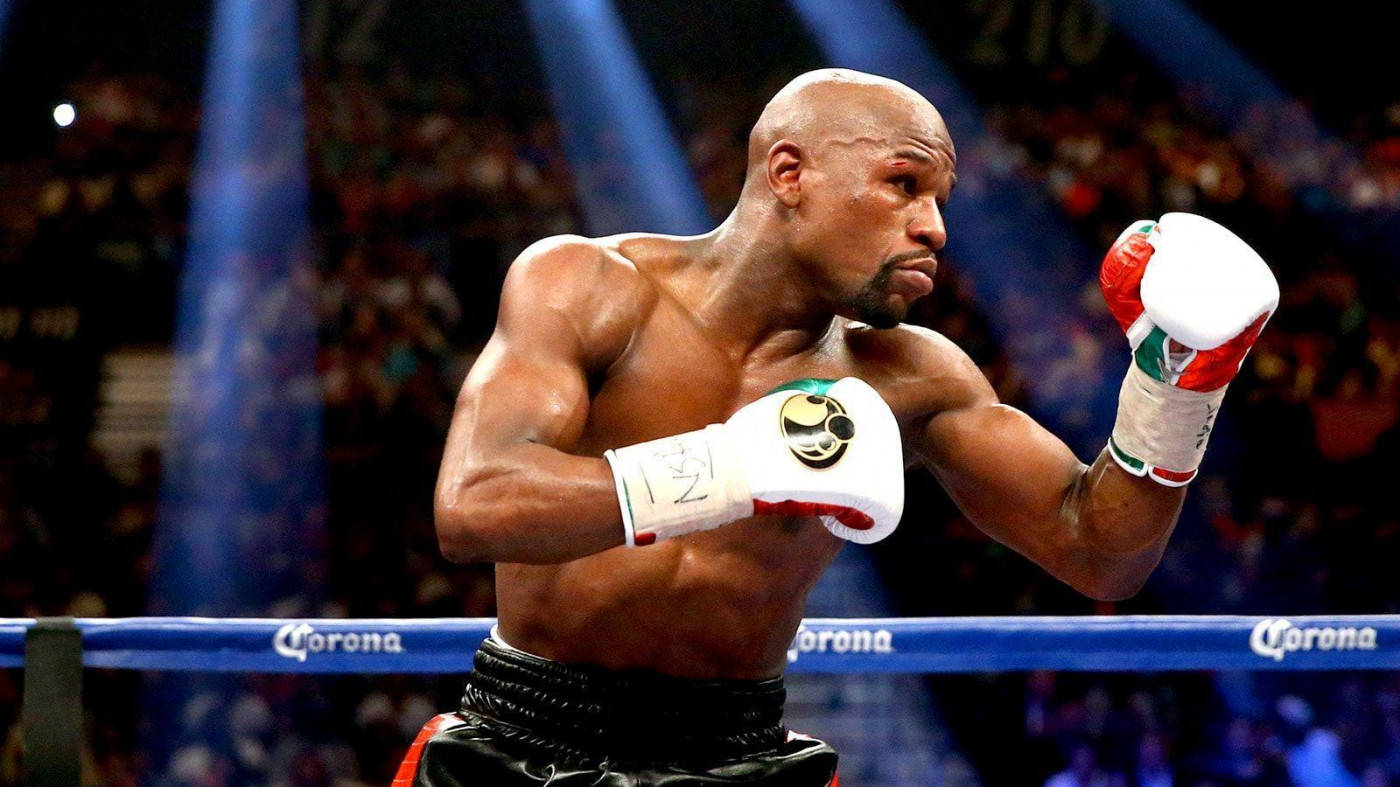 Floyd Mayweather Raising His Boxing Gloves Background