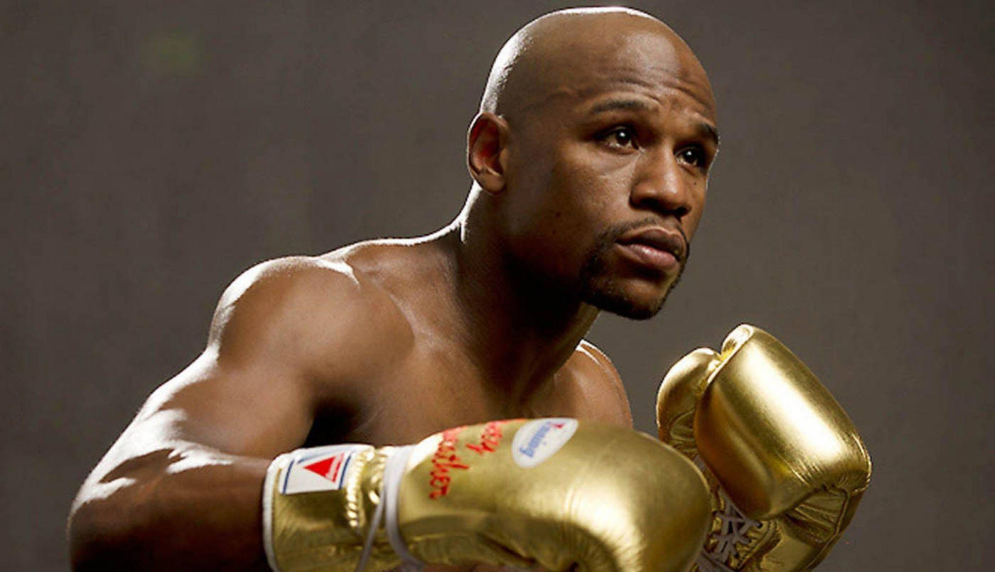 Floyd Mayweather Wearing Golden Boxing Gloves Background