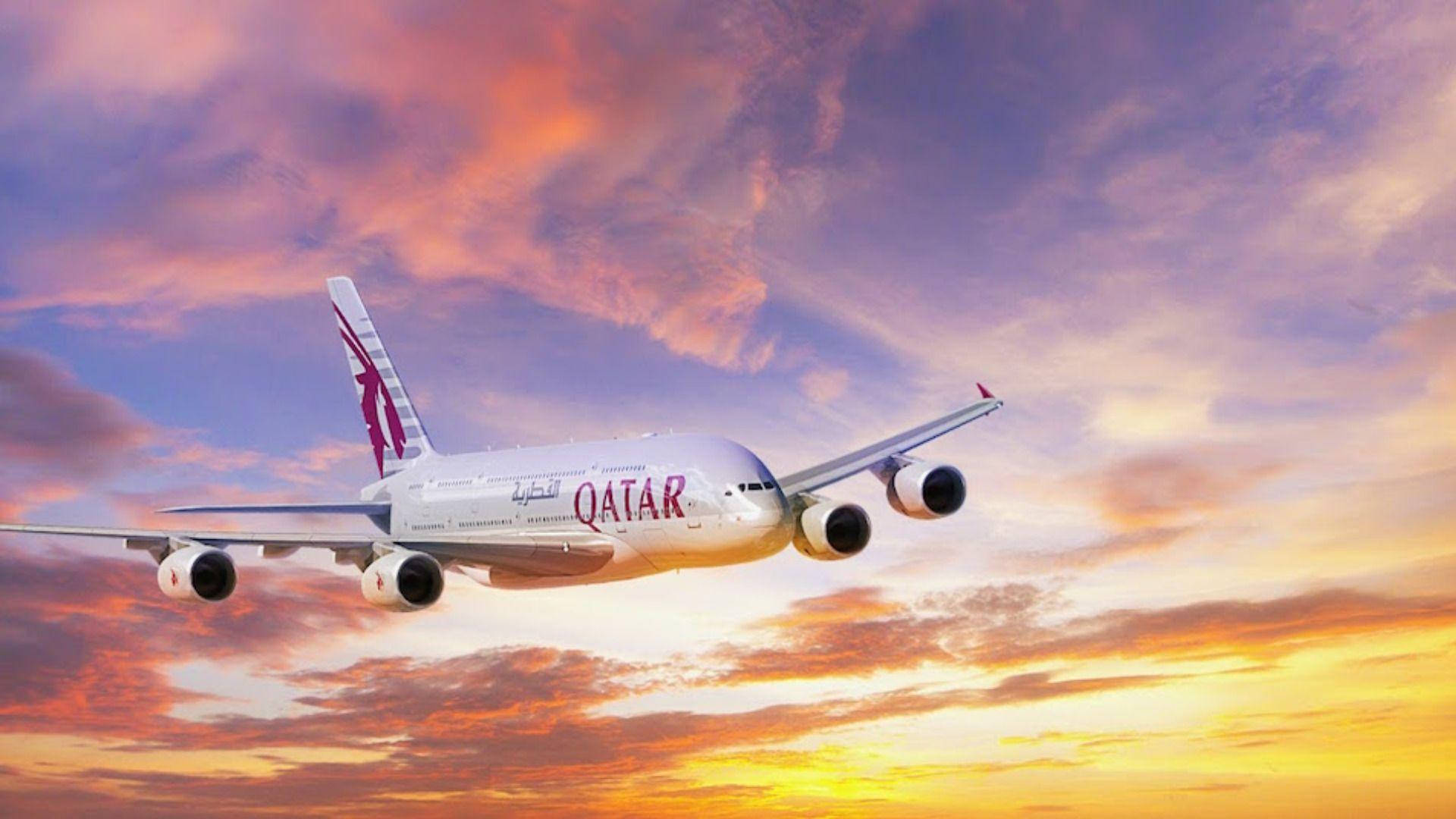 Flying Qatar Airways Plane Amidst An Ombré Sky Background