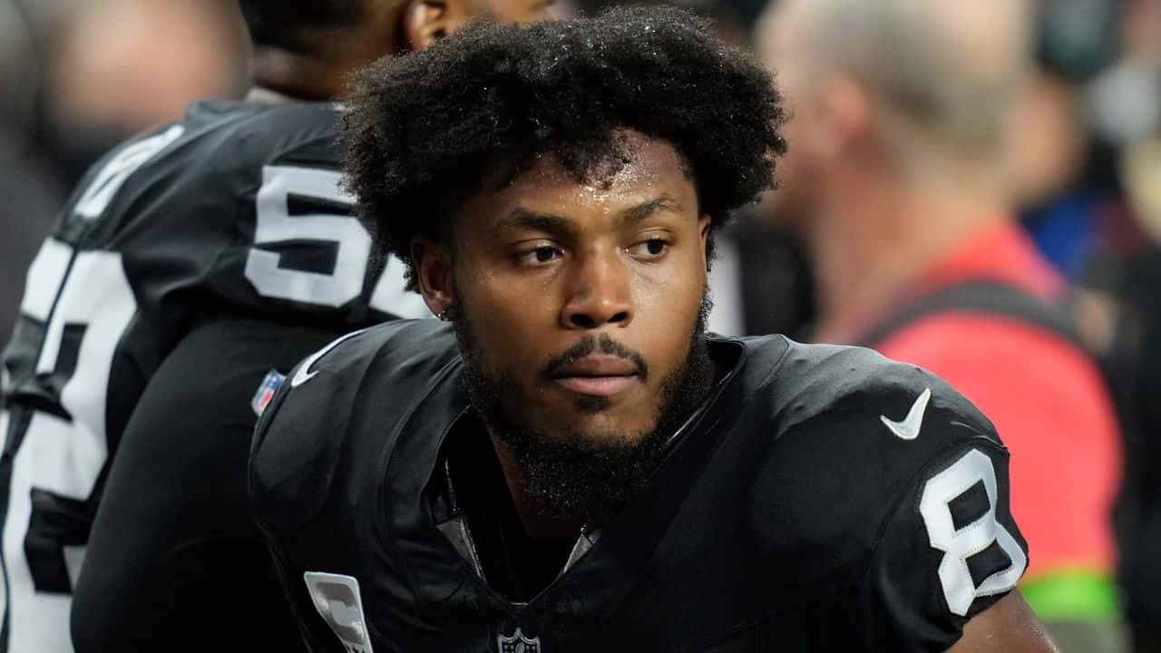 Focused Football Player Resting During Game Background