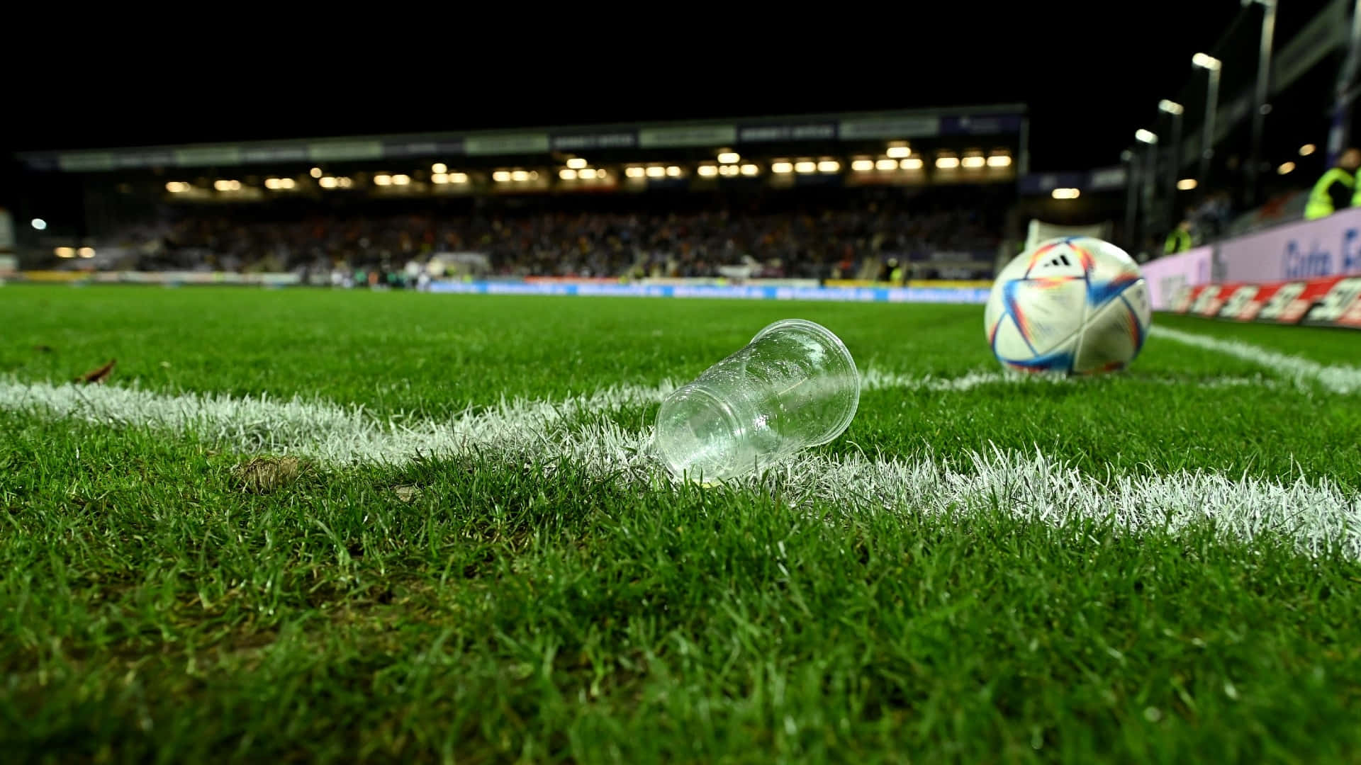 Football Field With Soccer Ball And Plastic Cup Background