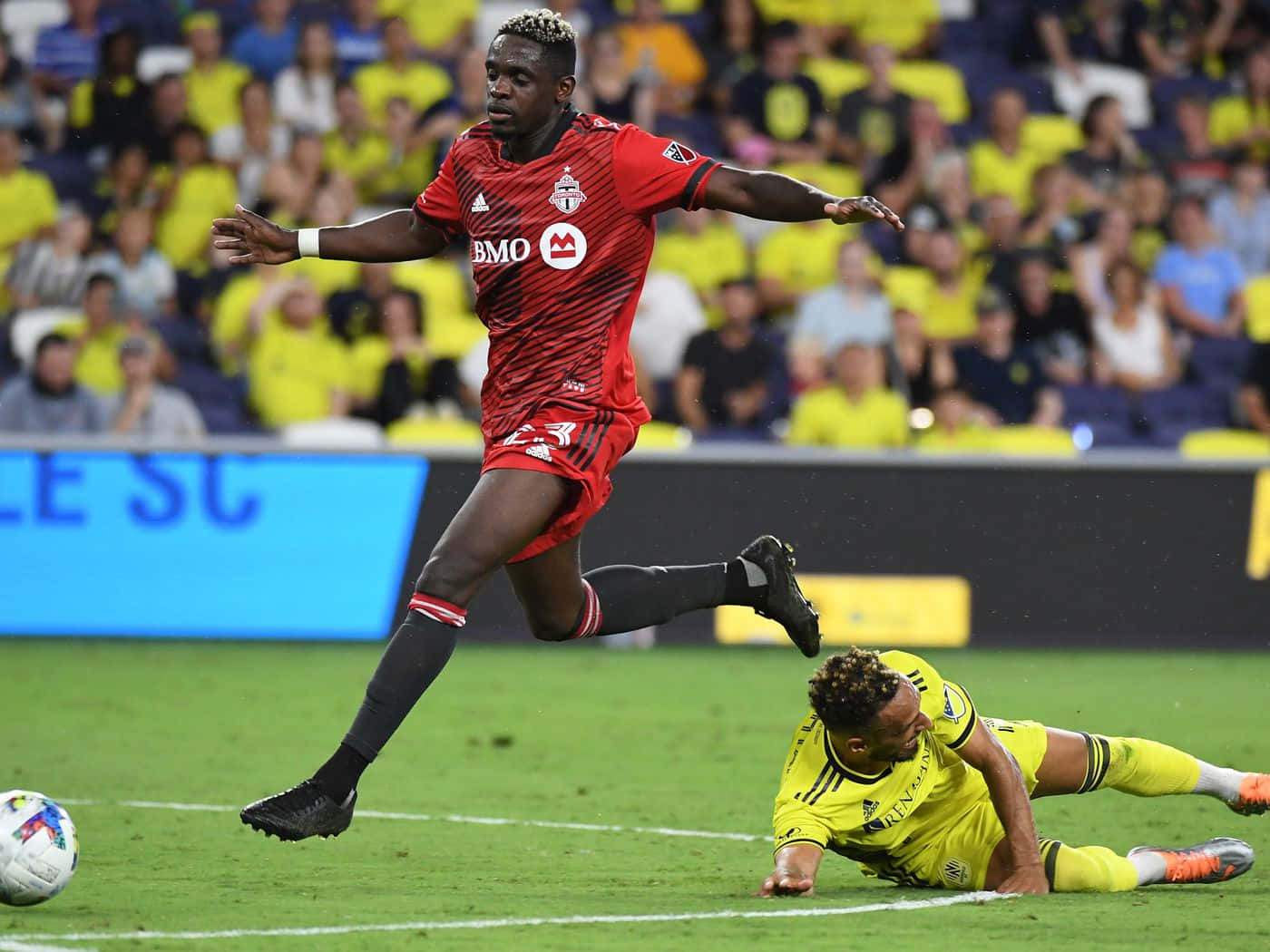 Football Player Chris Mavinga With Opponent Down Background