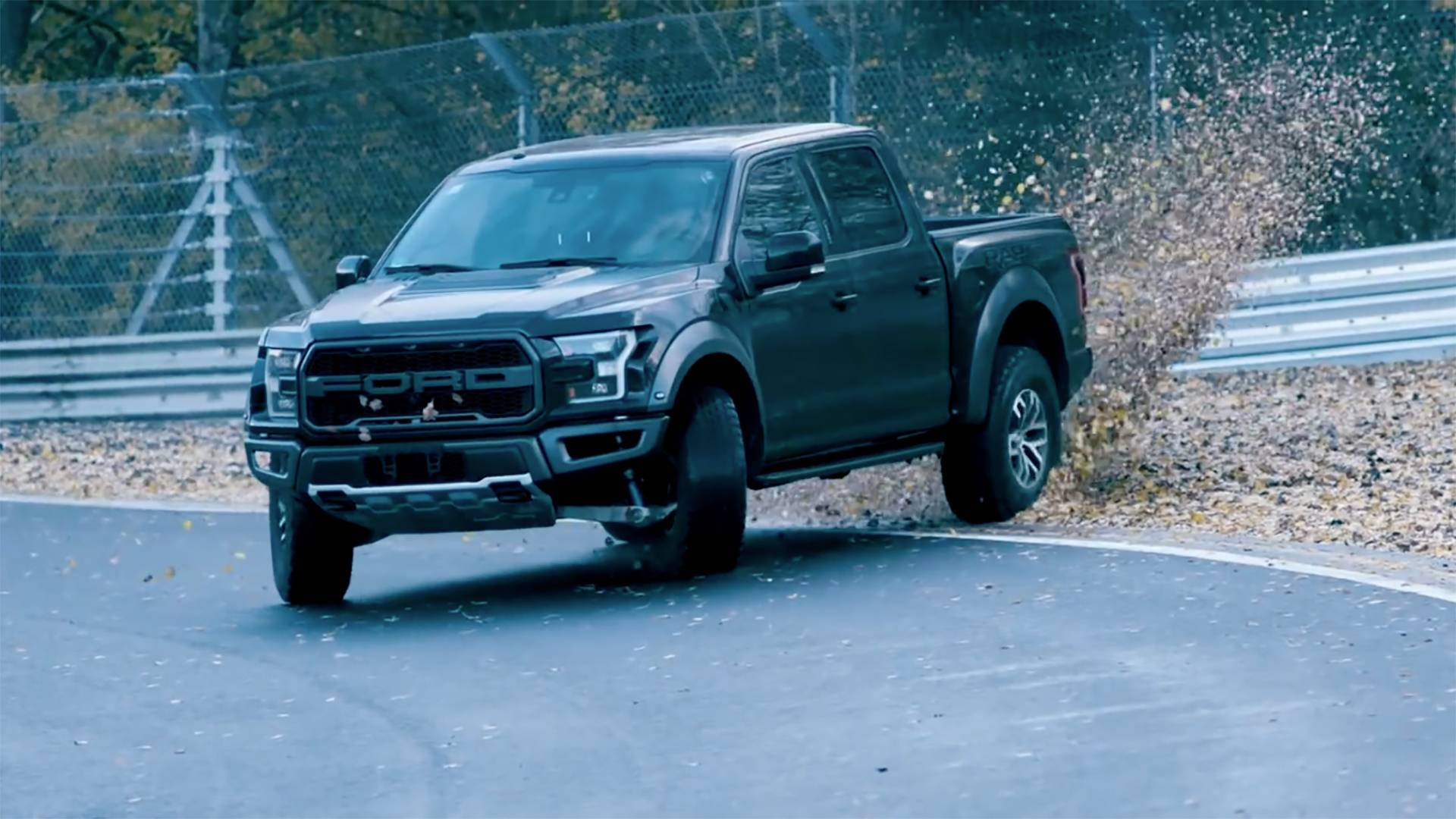 Ford F-150 Raptor - A Black Truck Driving On A Track