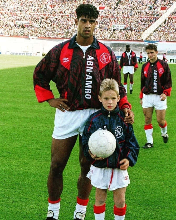 Former Football Manager Frank Rijkaard And Young Boy Background
