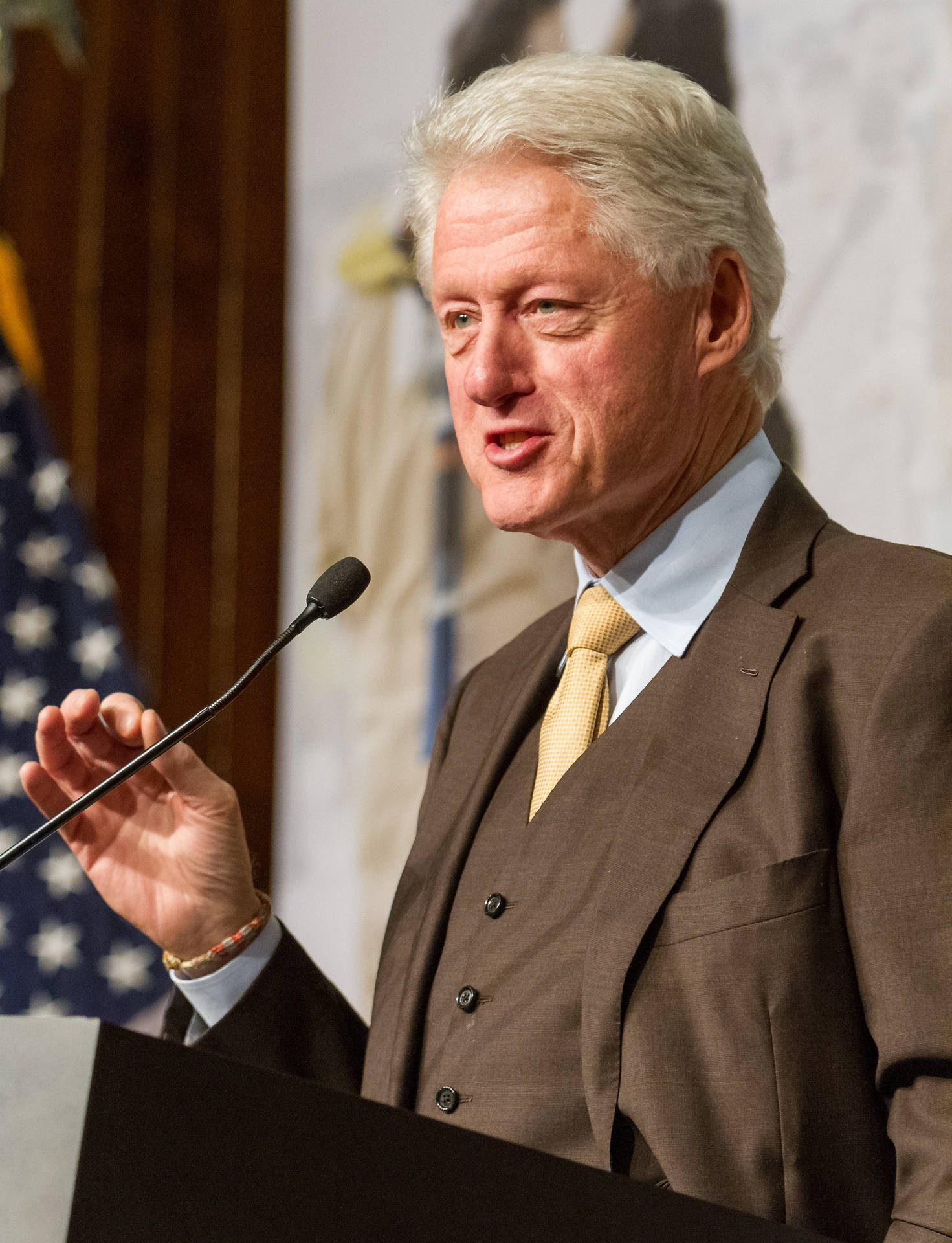 Former President Bill Clinton In Elegant Brown Tuxedo Background