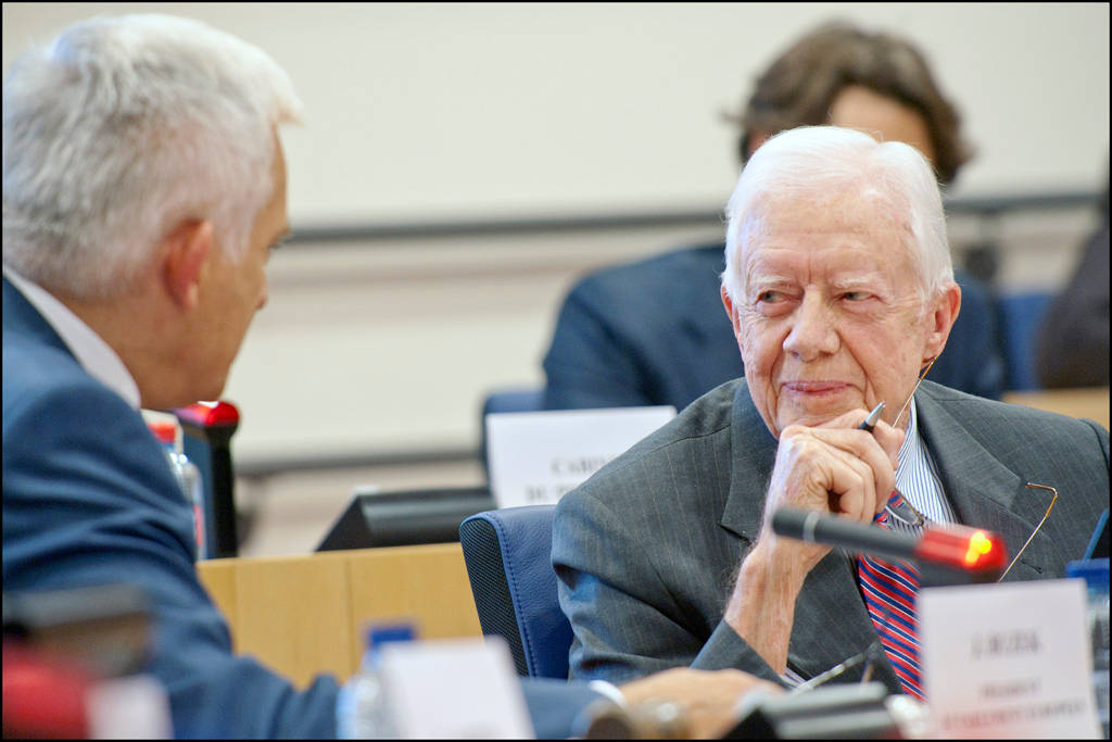 Former President Jimmy Carter Engaging In A Serious Discussion Background