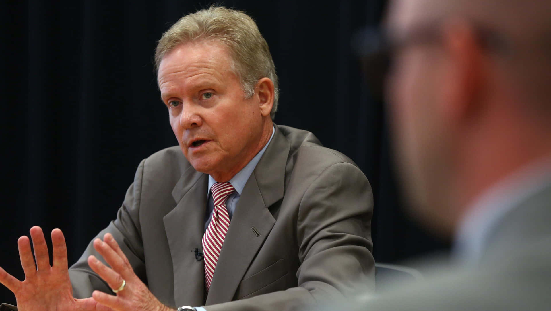 Former Senator Jim Webb Engaged In A Strategic Meeting Background