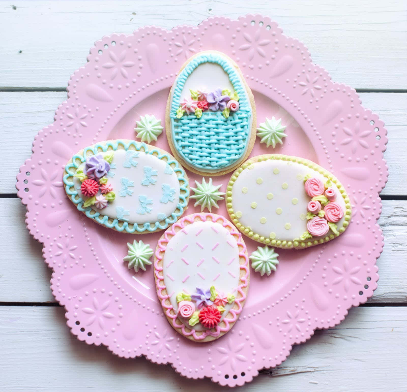 Four Cookies Decorated With Flowers And A Basket