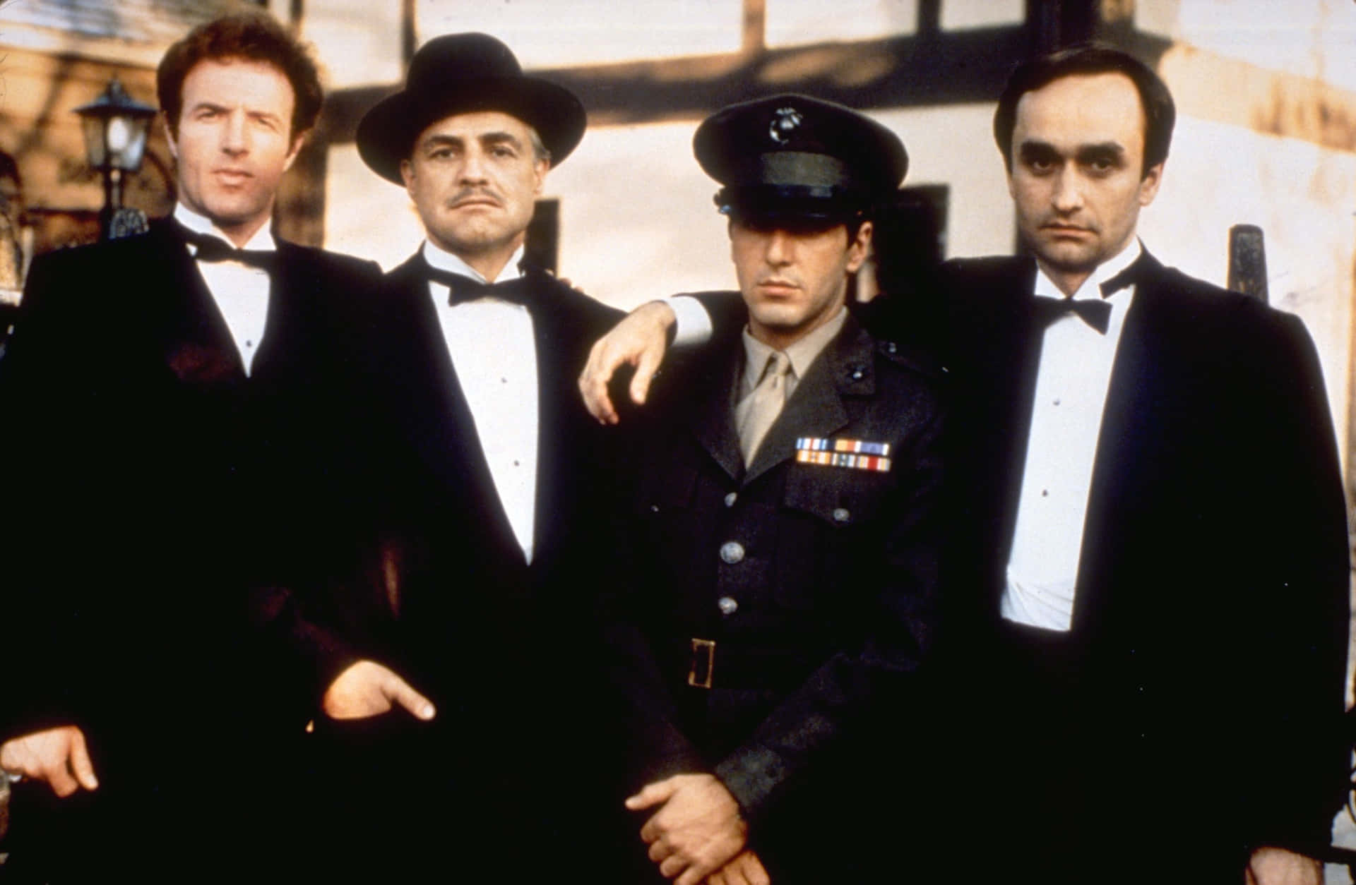 Four Men In Suits Standing Next To Each Other Background