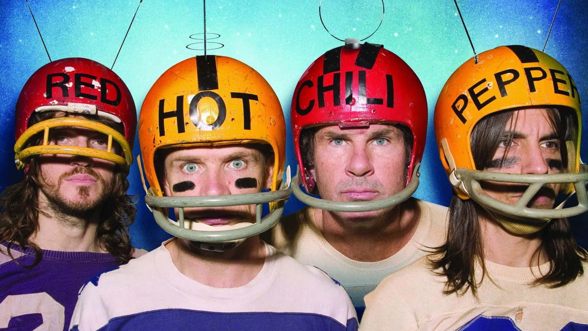 Four Men Wearing Helmets With Red, Hot, And Pepper Background