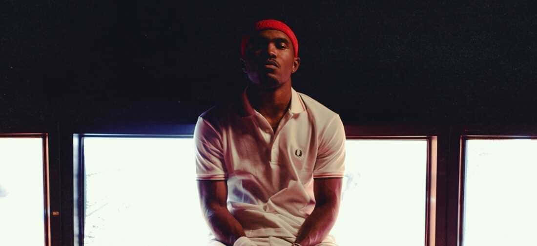Frank Ocean Engrossed In His Laptop Work Background