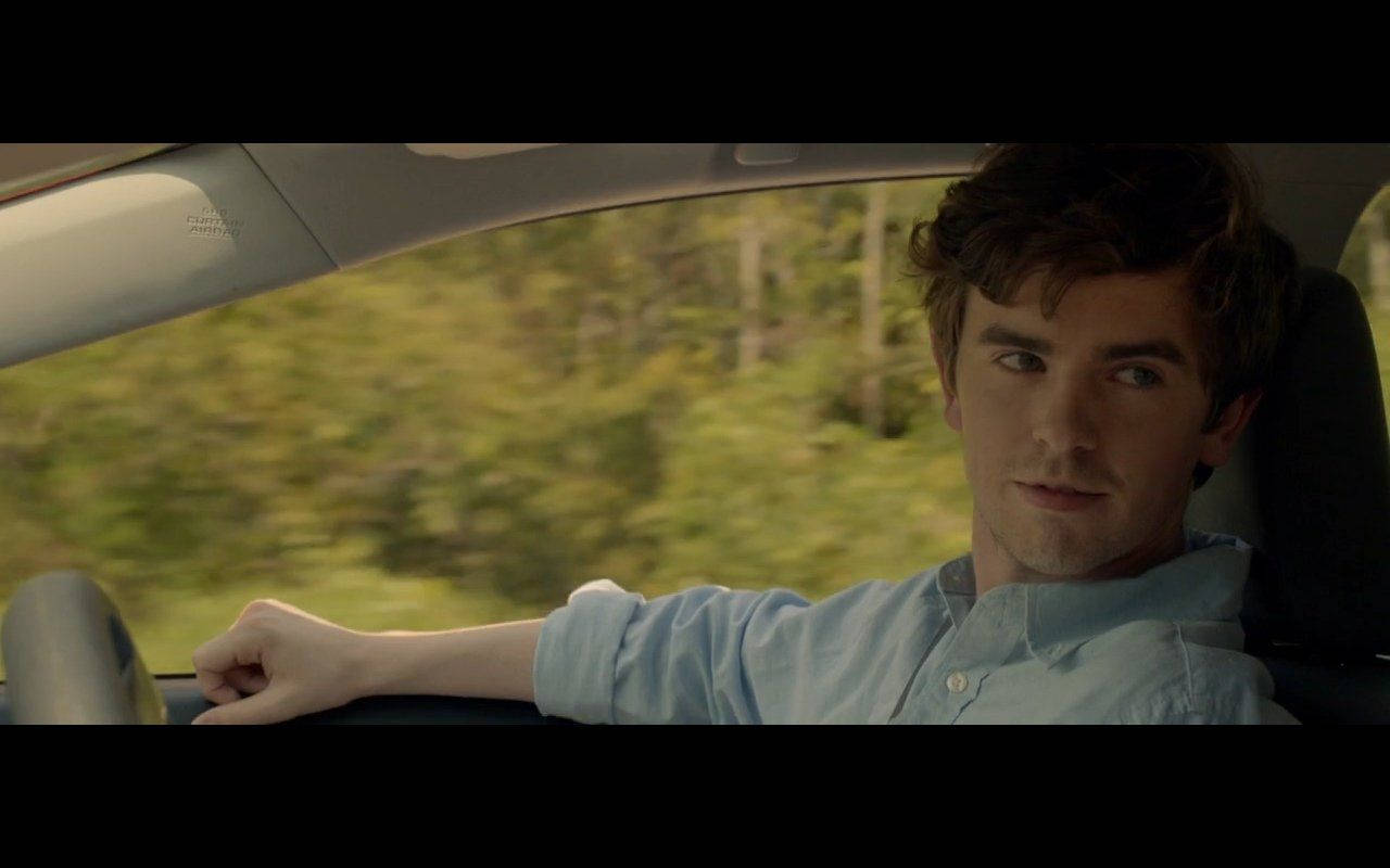 Freddie Highmore Casually Leans On A Car Background