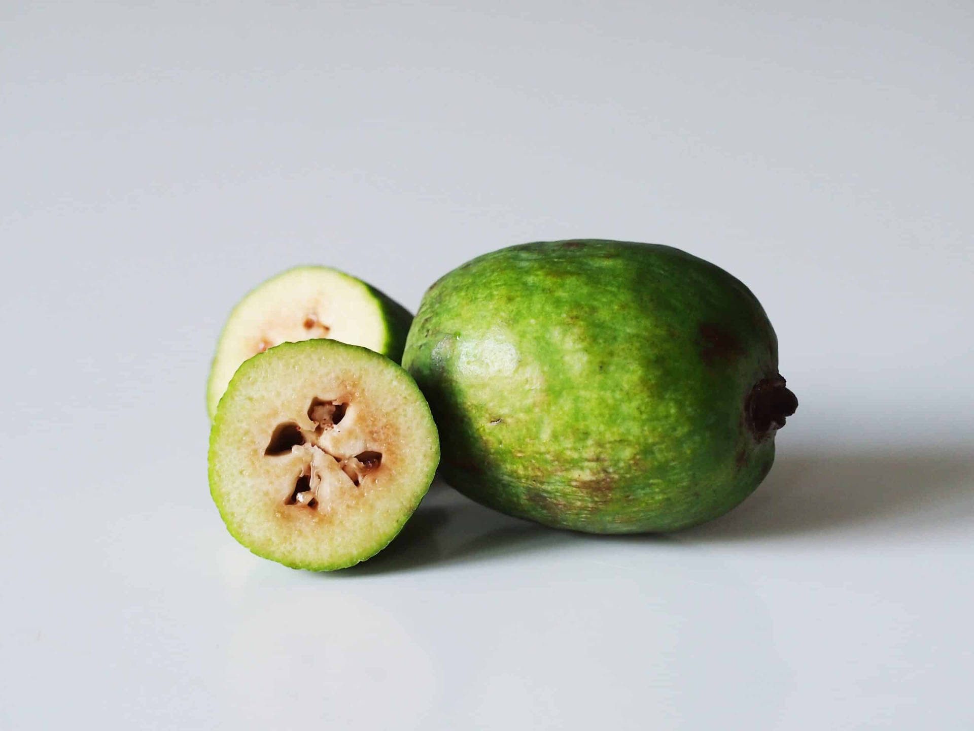 Fresh And Delicious Feijoas - Whole And Halved Background