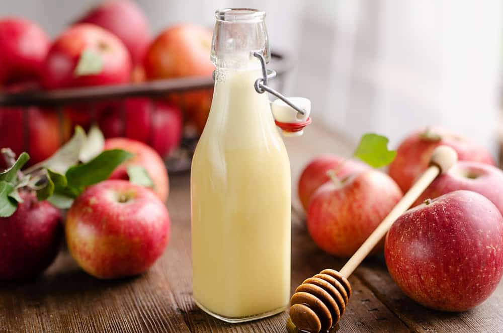 Fresh Apple Cider Vinegar In A Glass Bottle Background