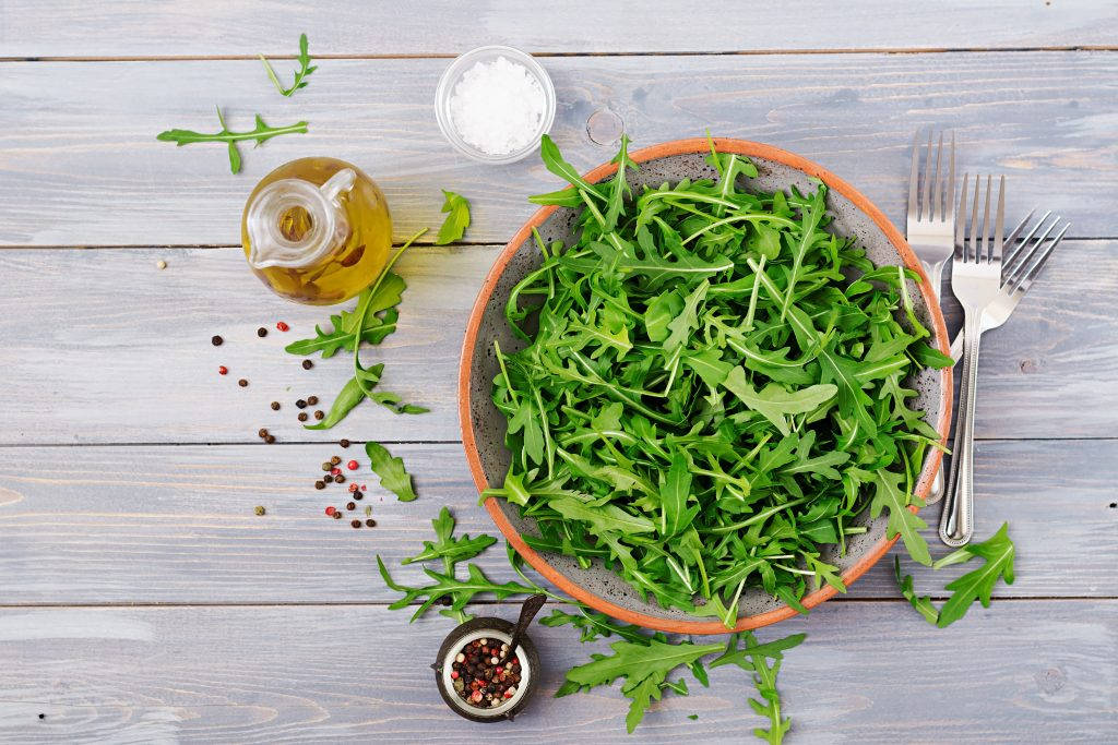 Fresh Arugula Salad Tossed In Olive Oil And Sauce