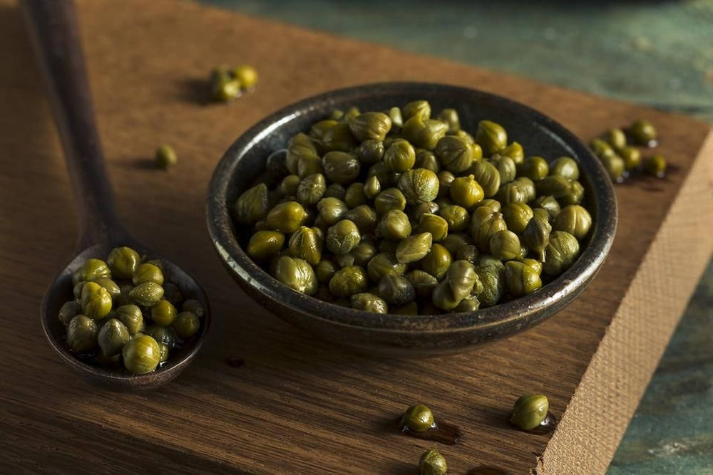 Fresh Capers In A Dark Soup Bowl