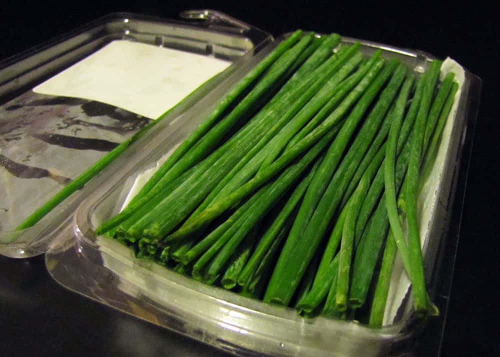 Fresh Garlic Chives On Plastic Packaging Background