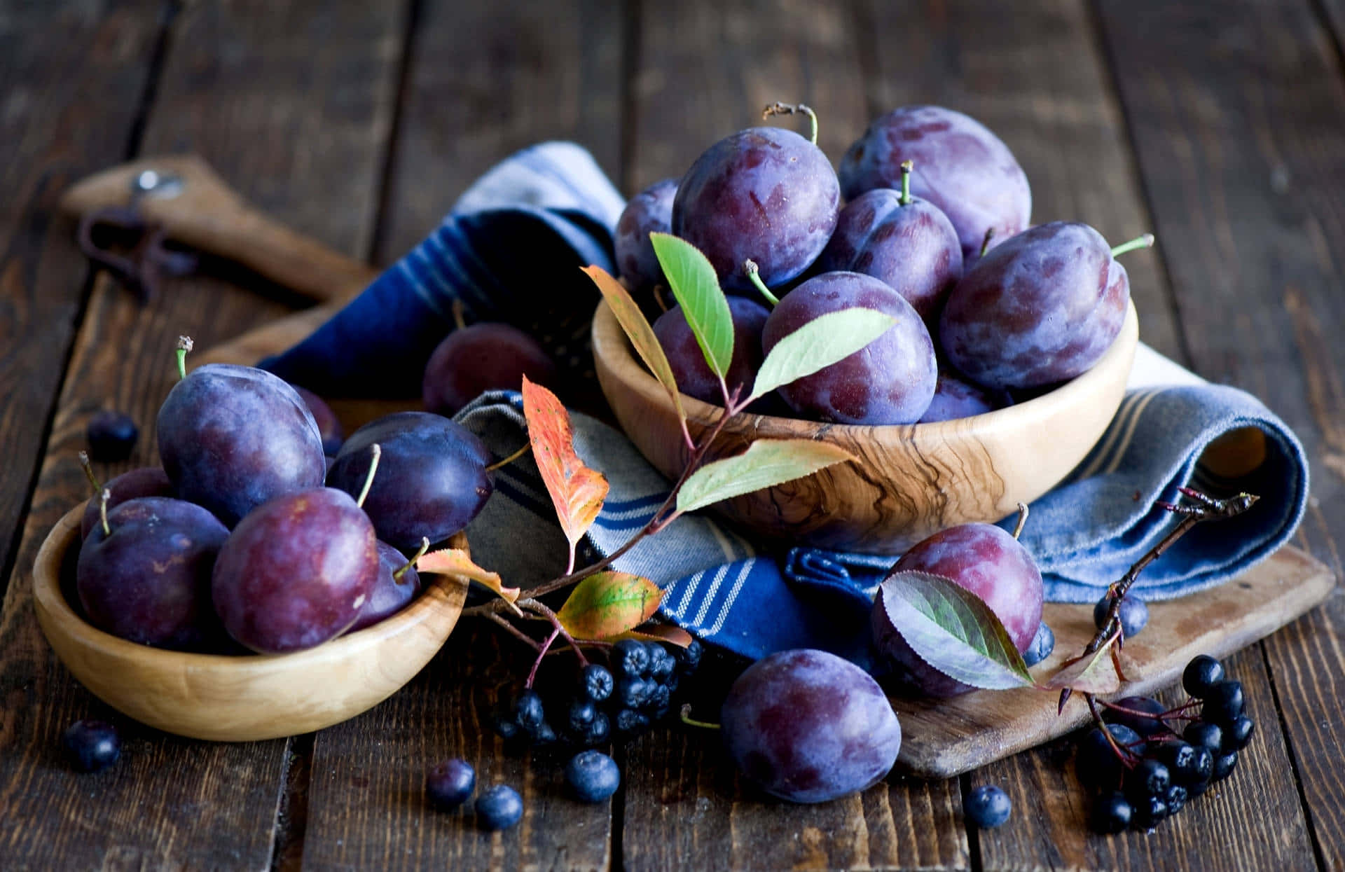 Fresh Italian Prune Plums And Blackberries In Wooden Bowls Background