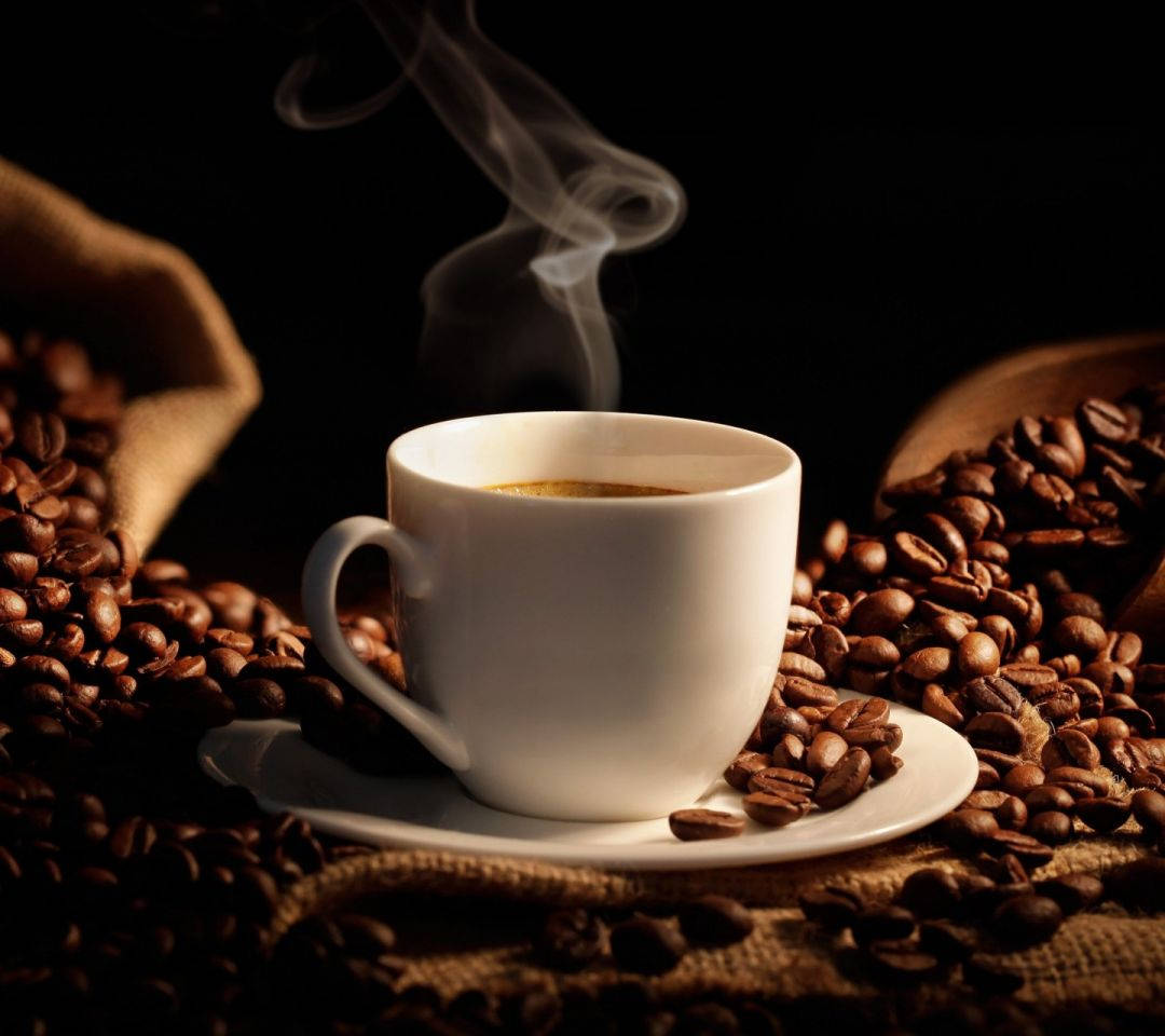 Fresh Mug Of Coffee With Coffee Beans Background