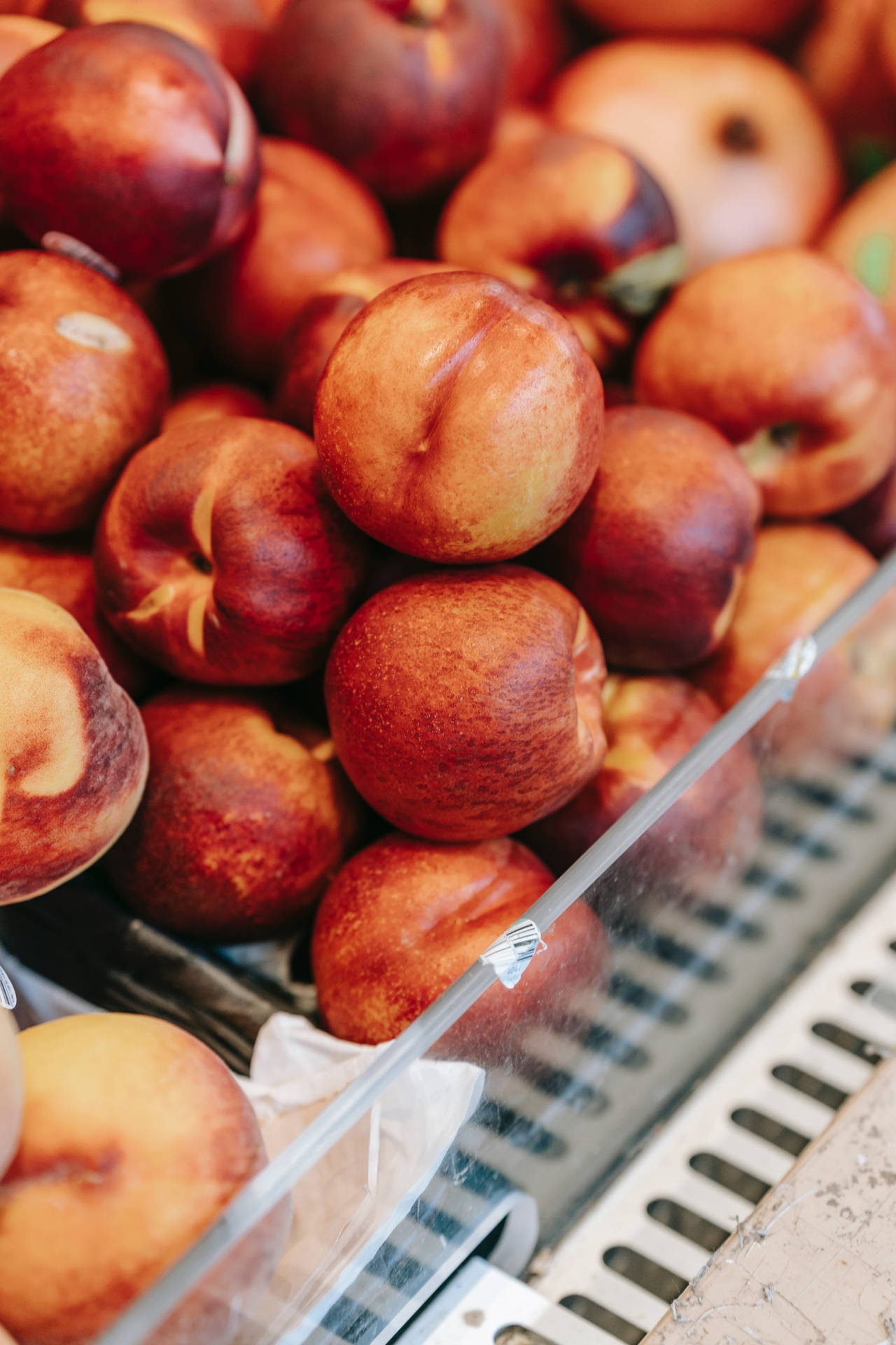 Fresh Nectarines Displayed In A Supermarket Fruit Section Background