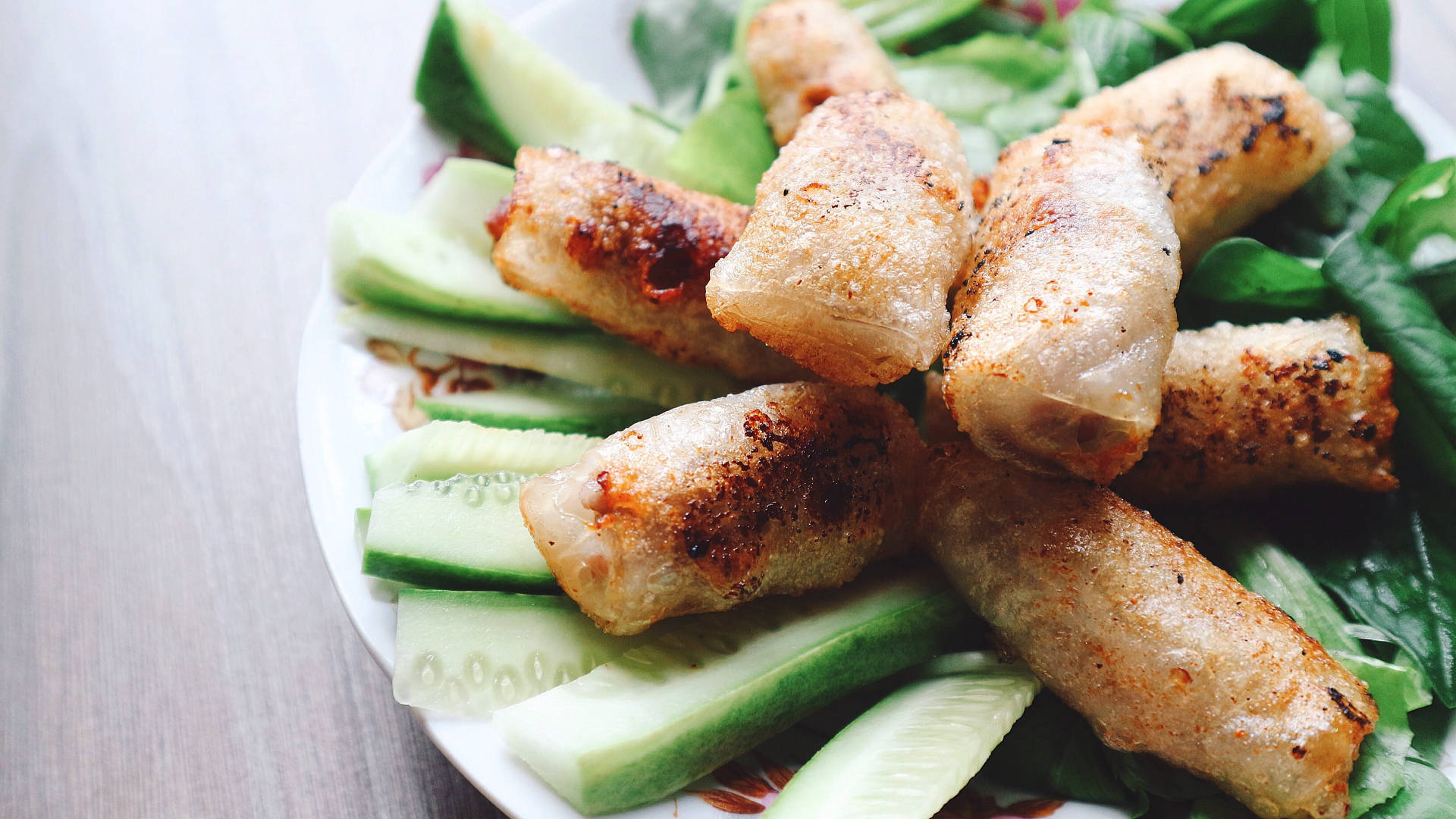 Freshly Made Egg Rolls Stacked On Sliced Cucumbers