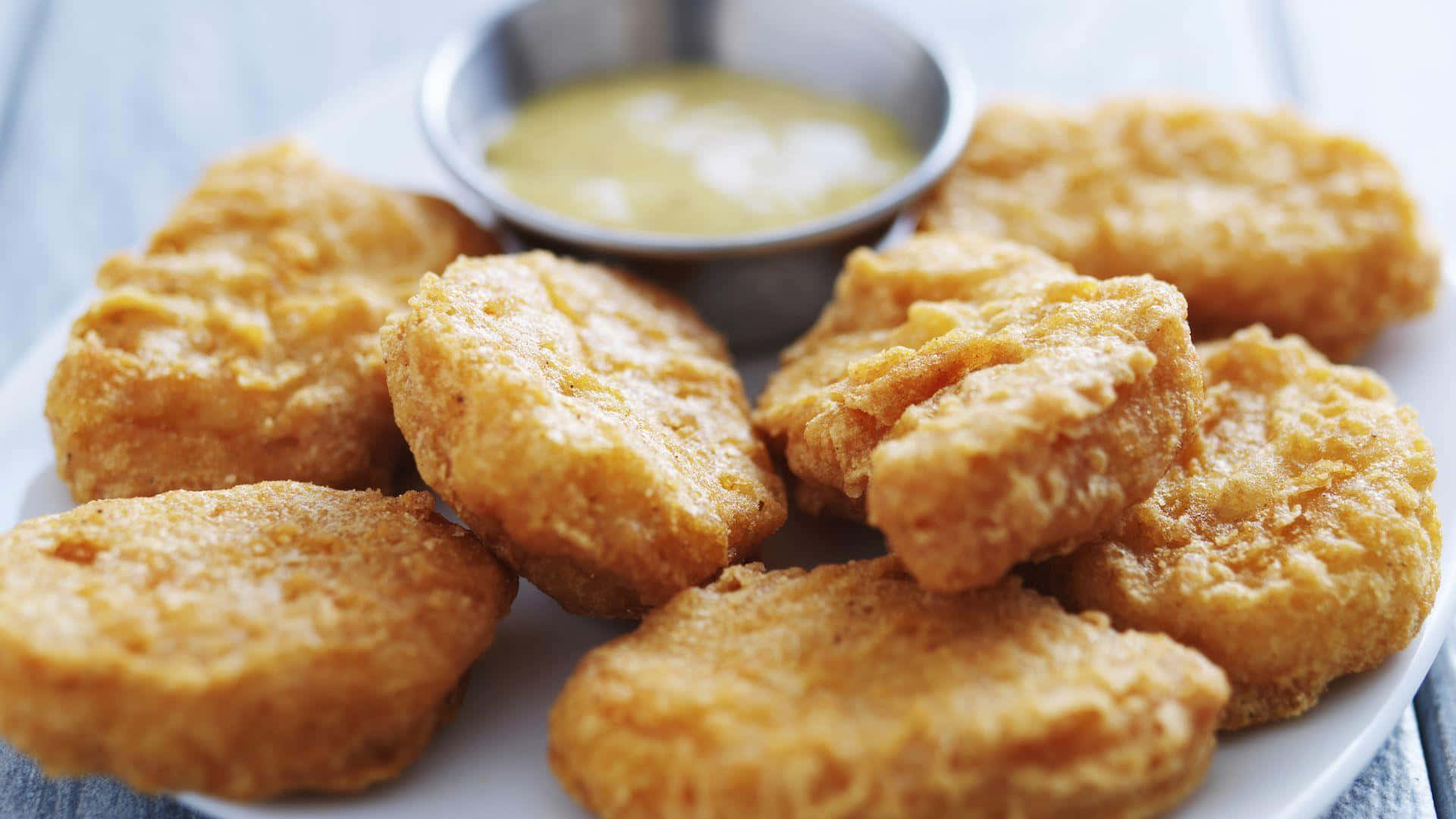 Fried Chicken Nuggets With Dipping Sauce On A Plate Background