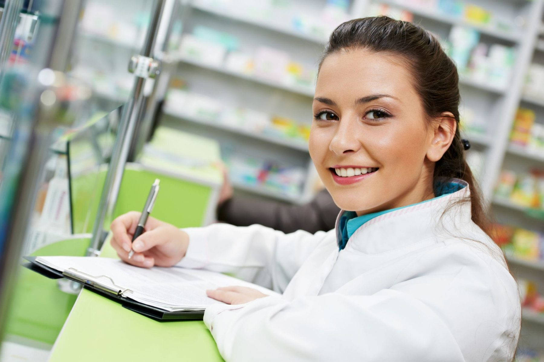 Friendly Female Pharmacist In A Pharmacy Background