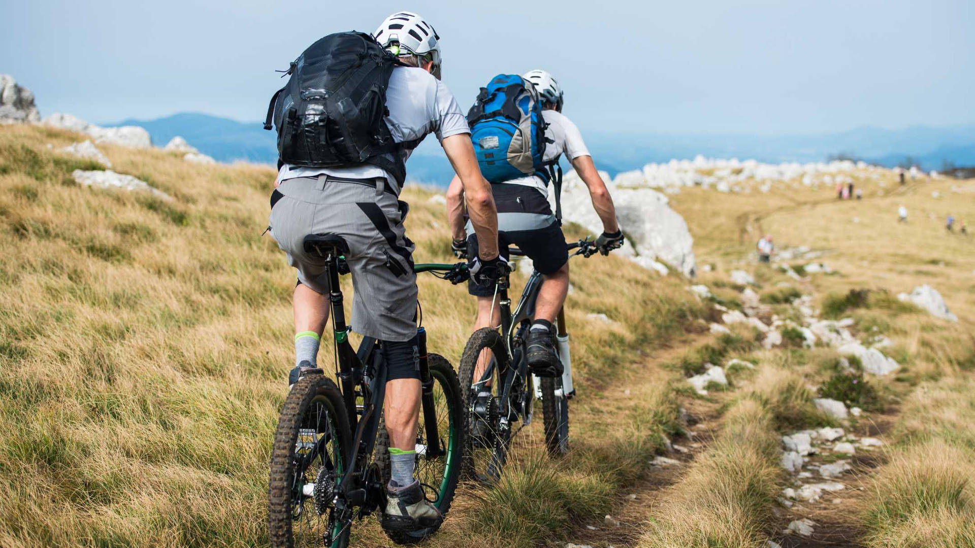 Friends Mountain Biking Towards Cap De Formentor Background