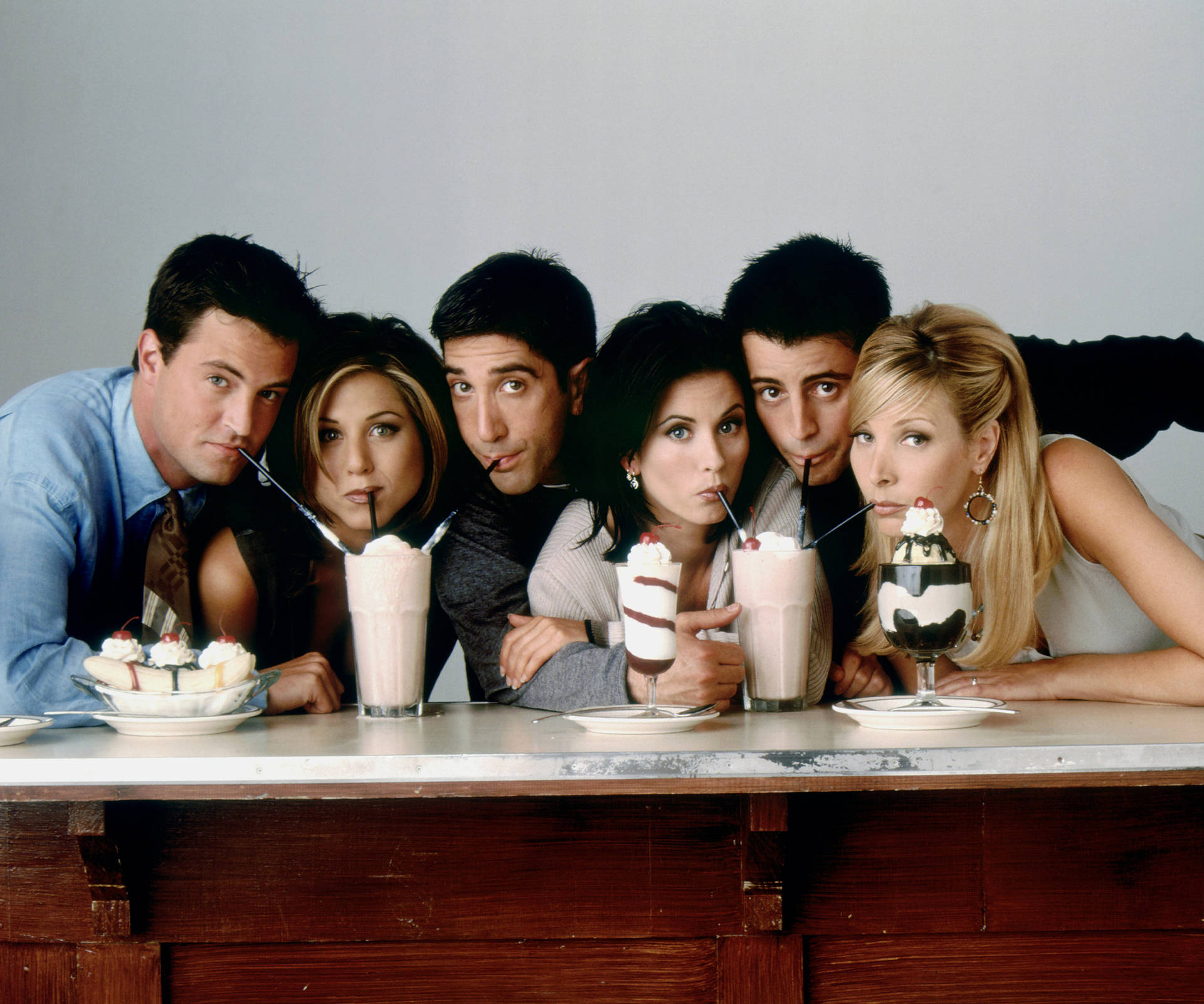 Friends Tv Show Cast Sharing Milkshakes Background